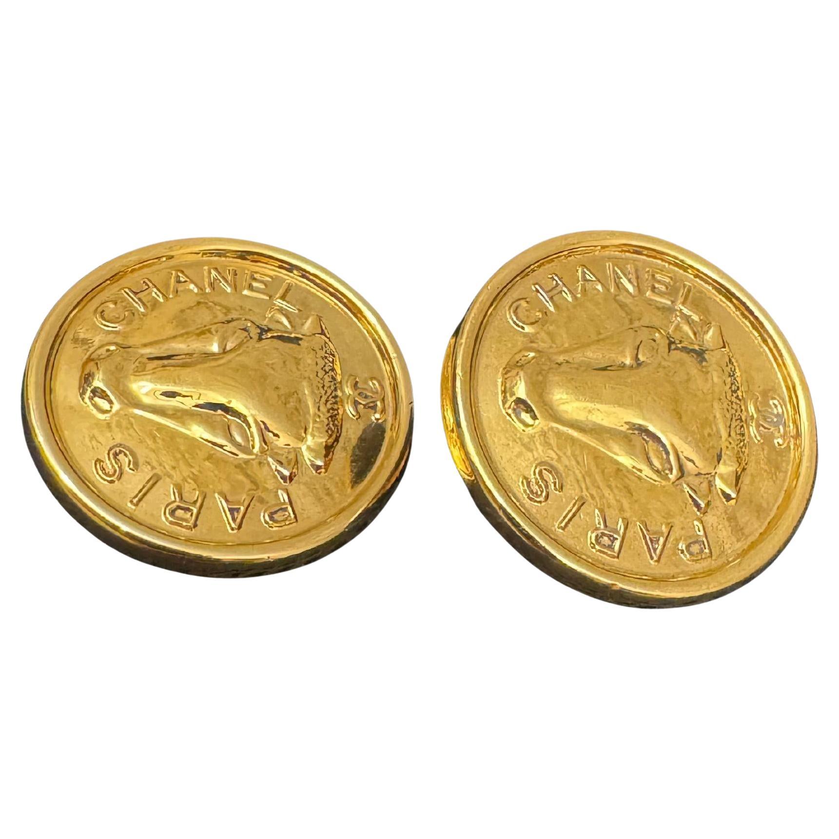 These vintage CHANEL clip-on earrings are crafted of gold plated metal featuring a bull’s head. Clip on style. Stamped CHANEL. Diameter measures approximately 3.0 cm. Come with box. 

Condition - Excellent vintage condition with minimal signs of wear