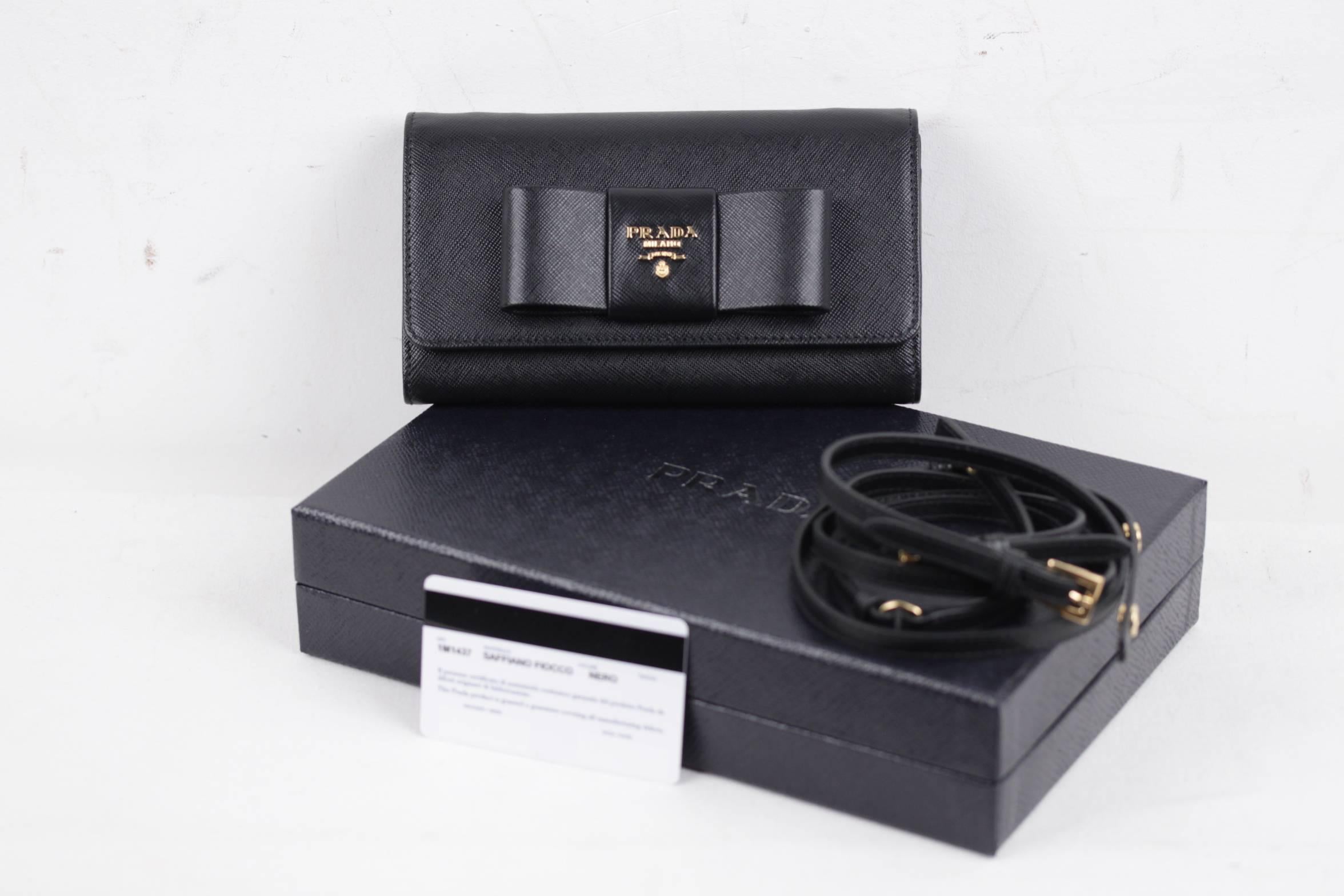 
- Saffiano leather flap wallet with leather bow on the front
- Color. Black (official PRADA color is NERO)
- Art. 1M1437 - SAFFIANO FIOCCO
- Gold-plated hardware
- PRADA Metal lettering logo
- Snap closure
- 6 credit card slots
- 1 coin