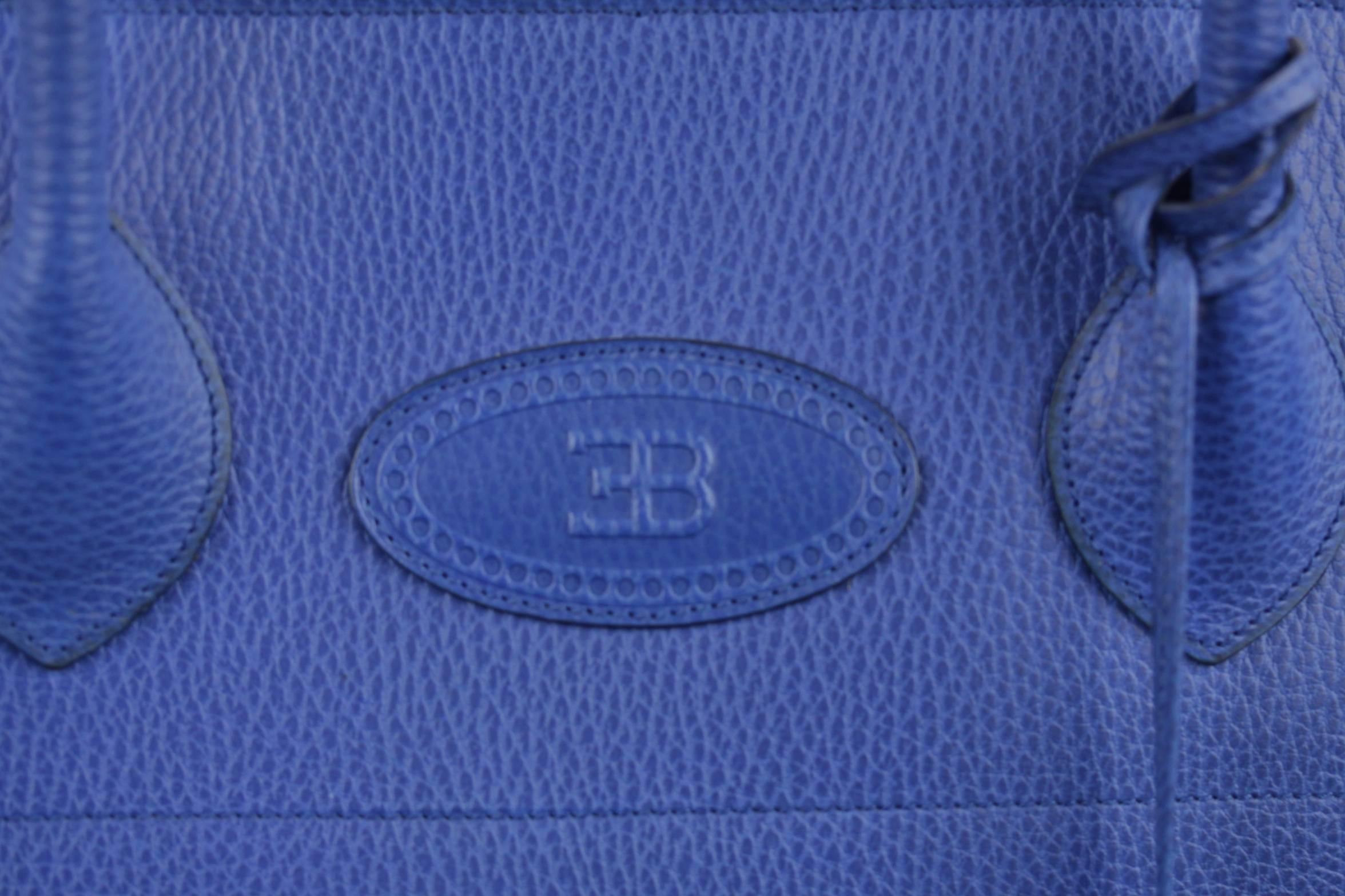  - Limited edition, numbered, large ETTORE BUGATTI satchel from the early 90s

- Crafted in genuine leather in an elegant electric blu color

- Its rounded line reproduced the curve of a Bugatti car's grille, the distinctive 'horseshoe