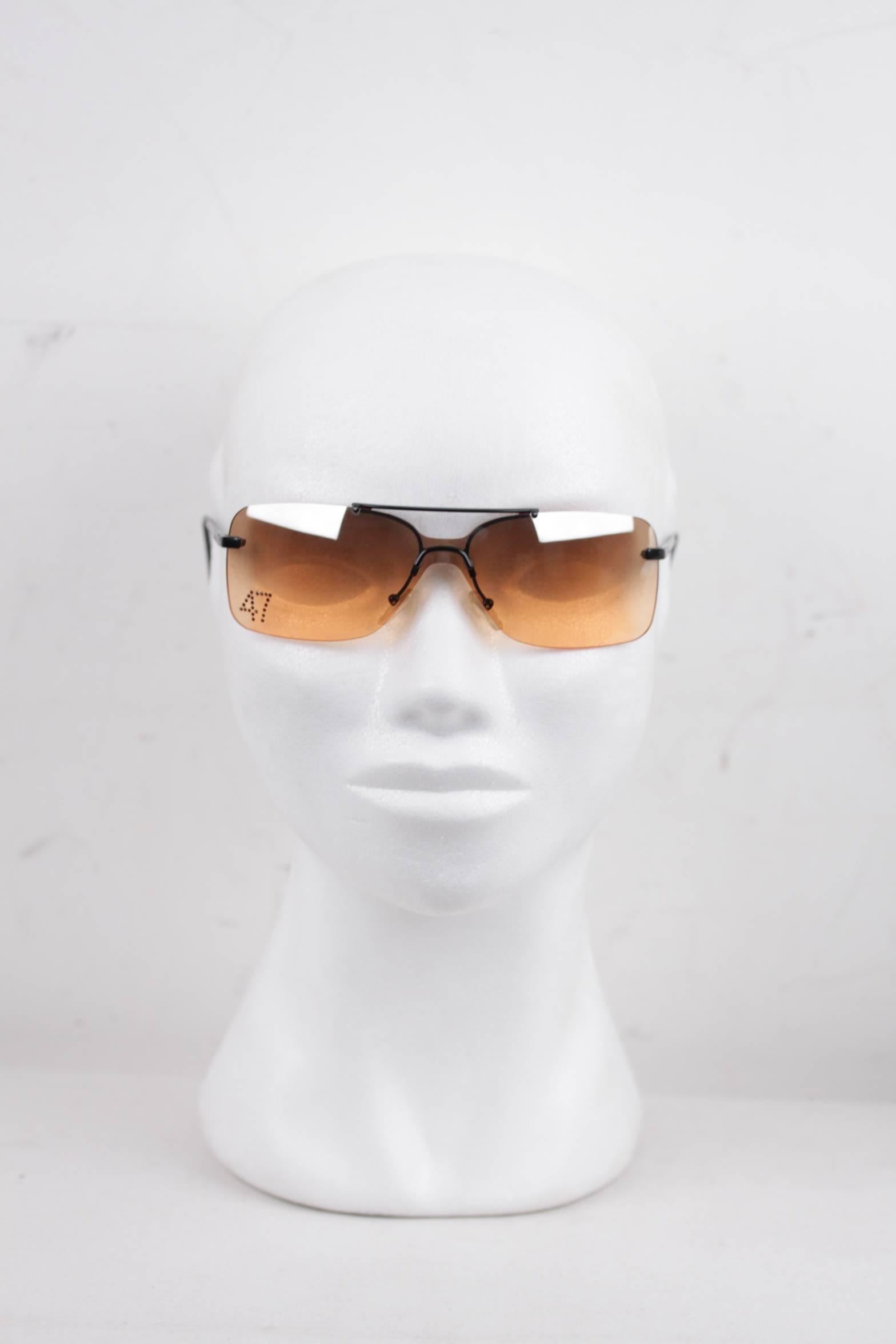 - CHRISTIAN DIOR - Made in Austria

- Style Name & Number: DIOR 47 - 90C - 125

- Rimeless frame with black metal arms

- CHRISTAIN DIOR signature engraved on temples

- Gradient/Faded orange one-piece lens

- '47' number made in small