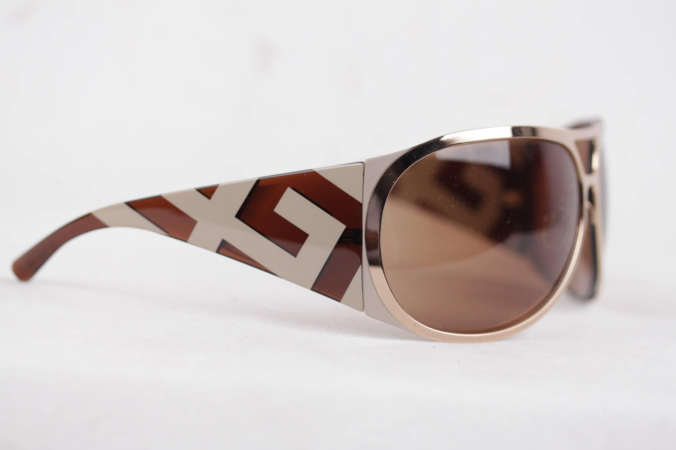 - Wrap sunglasses signed GIVENCHY

- Gold metal aviator-shaped front, with brown plastic arms (with geometric pattern

- Original Brown lenses

- Style & Ref: SGV 219 - Col. 300

Any other detail which is not mentioned may be seen on the