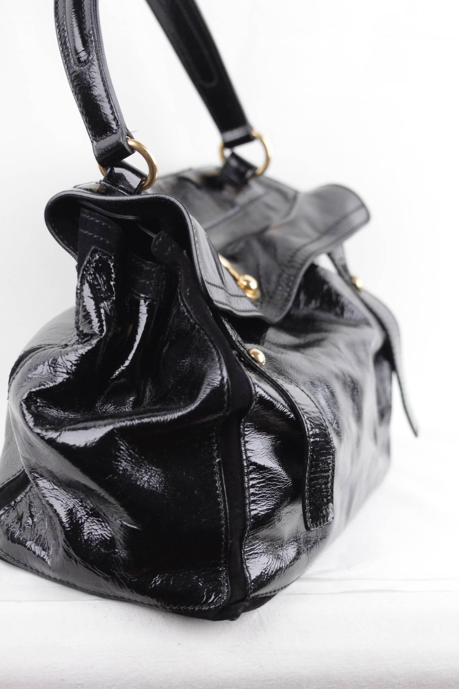 - Black patent leather
- Golden hardware
- Satchel shape
- Lined in black suede with interior pocket
- Interior center zip pocket
- Single handle
- Rear compartment and 4 protective bottom feet
- Approx.meauserements: 10 x 14 x 6 inches -