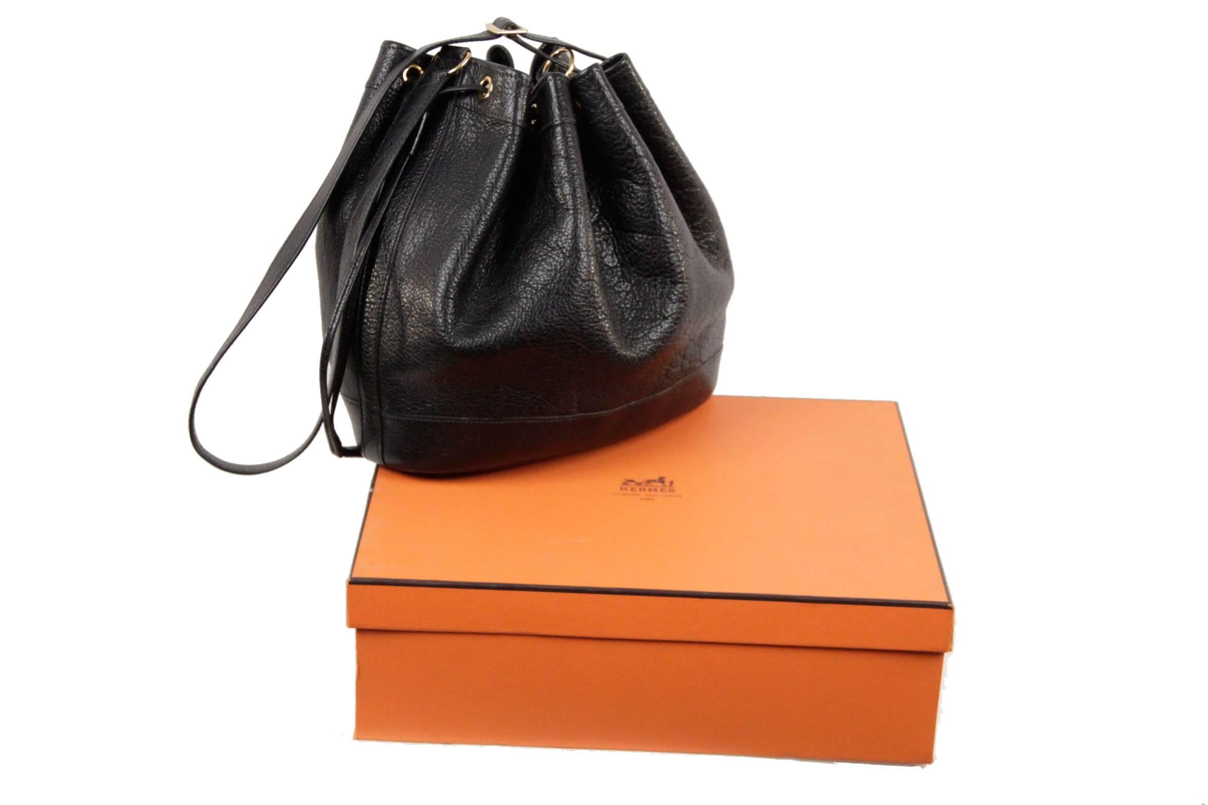 
- Hermès Vintage Leather 'Market' Bucket Bag
- Genuine Black leather
- Drawstring fasten with tassel detailing
- Adjustable leather strap
- Gold tone buckle
- Stitched detail
- Unlined
- Comes with a HERMES Orange box
- Approx.