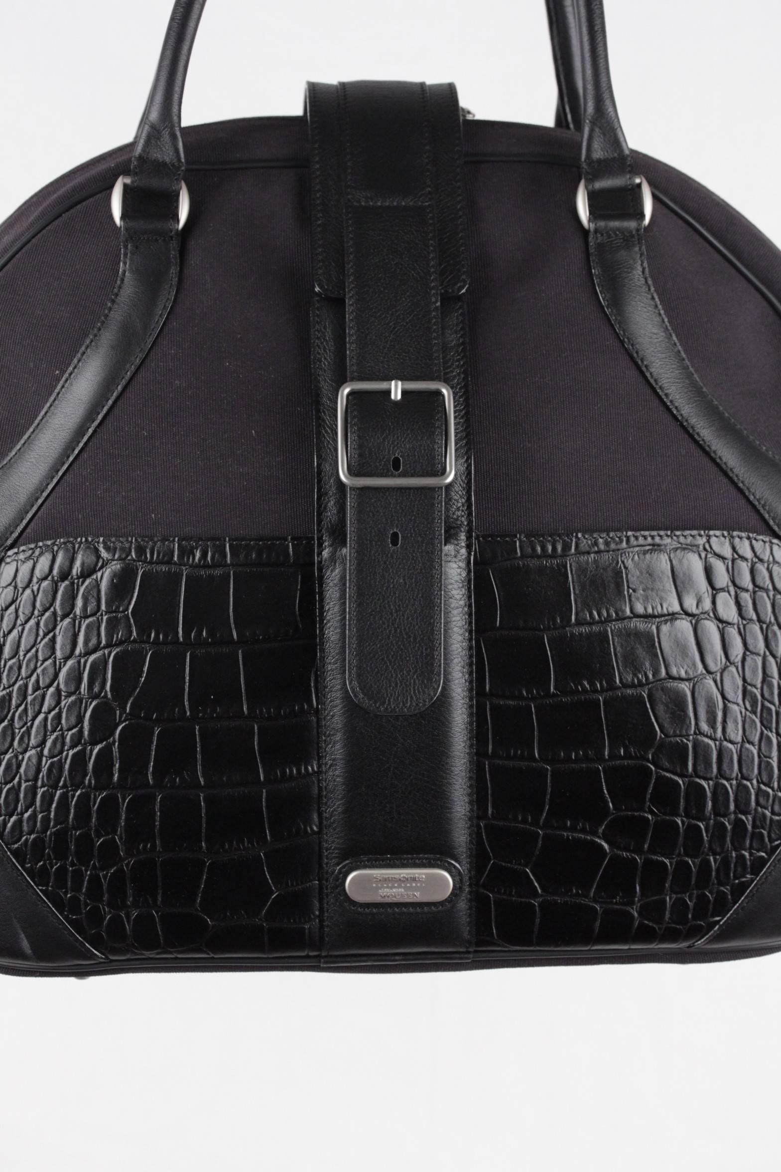  - Soft carry-on bag with unique shape
- Crafted in sturdy canvas and crocodile-embossed leather (cowhide)
- Leather carry handles
- Upper zipper closure + buckle closure
- Feather Print lining
- Inside zipper compartment and 2 open