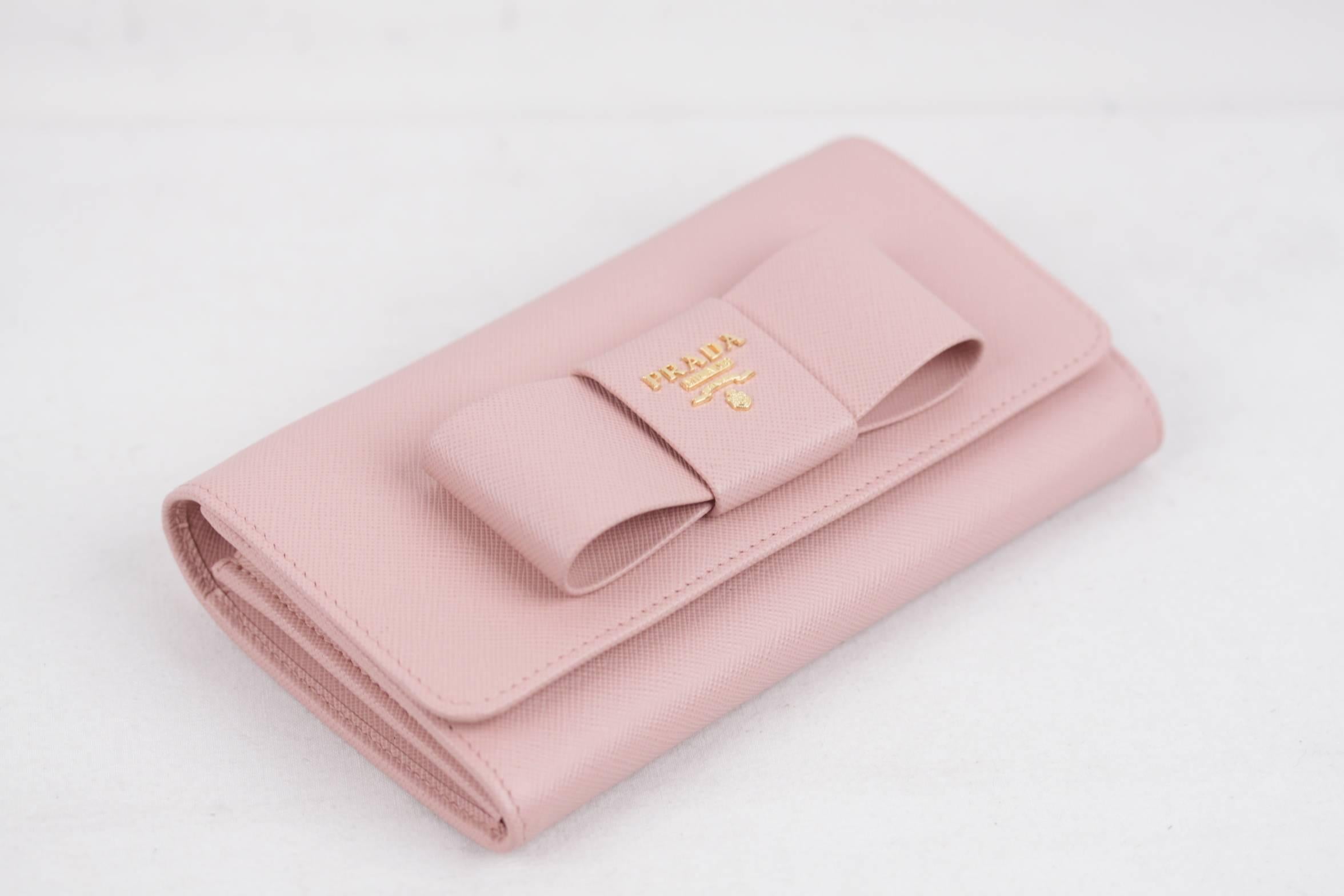 
- Saffiano leather flap wallet with leather bow on the front
- Colr. Pink (official PRADA color is ORCHIDEA)
- Art. 1M1437 - SAFFIANO FIOCCO
- Gold-plated hardware
- PRADA Metal lettering logo
- Snap closure
- 6 credit card slots
- 1 coin