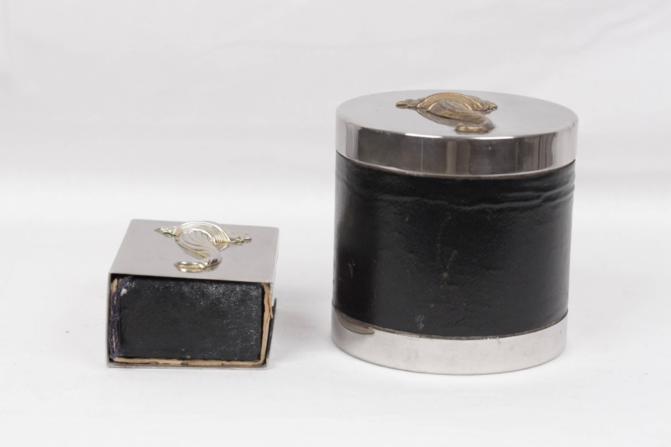  - Unique and rare vintage Hermes smoking set
- This set comes with a cigarette holder canister and a matchbox holder.
- Silver, with black leather details and gold cornucopia detail on each piece
- Each piece is signed with 'HERMES Paris'
-