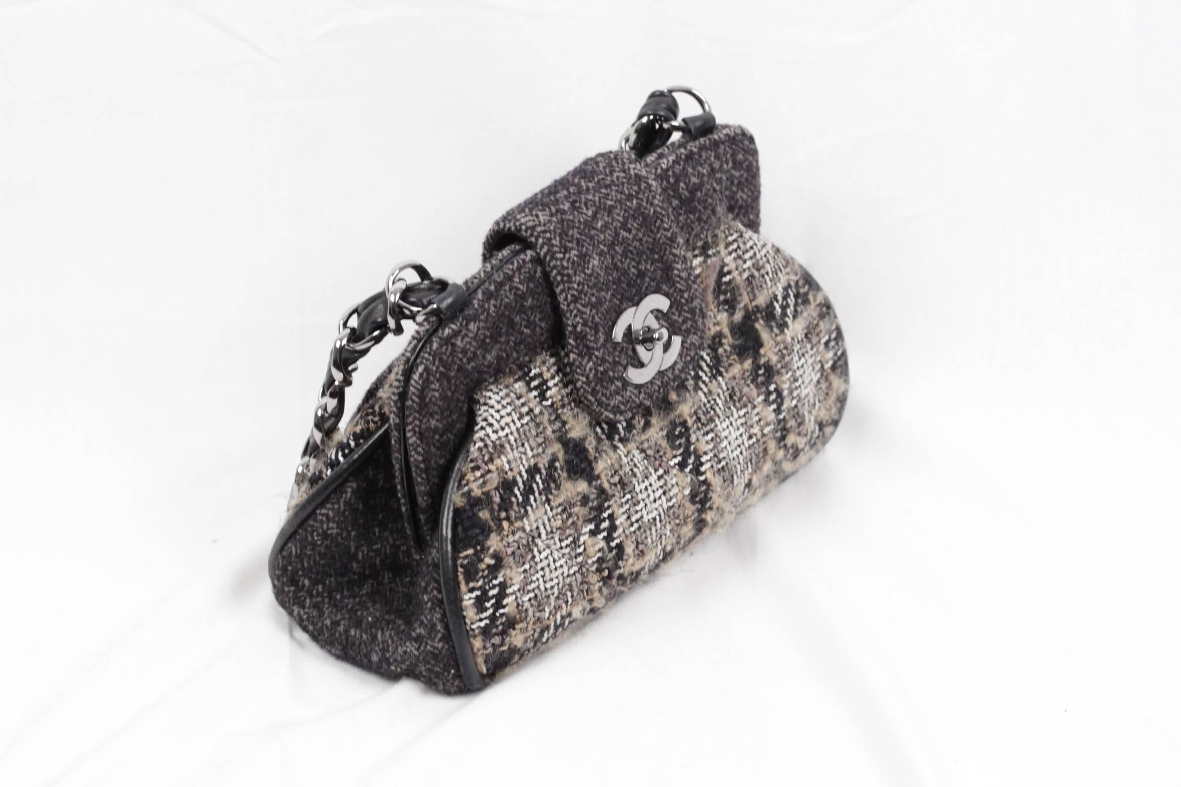 
- CHANEL Tweed Frame Bag
- Crafted of tweed and fine wool
- The bag features a large linked silver leather threaded shoulder strap
- Fold-over strap with CC CHANEL twist closure
-1 patch pocket on the back
- Black fabric lining
- 1 side zip