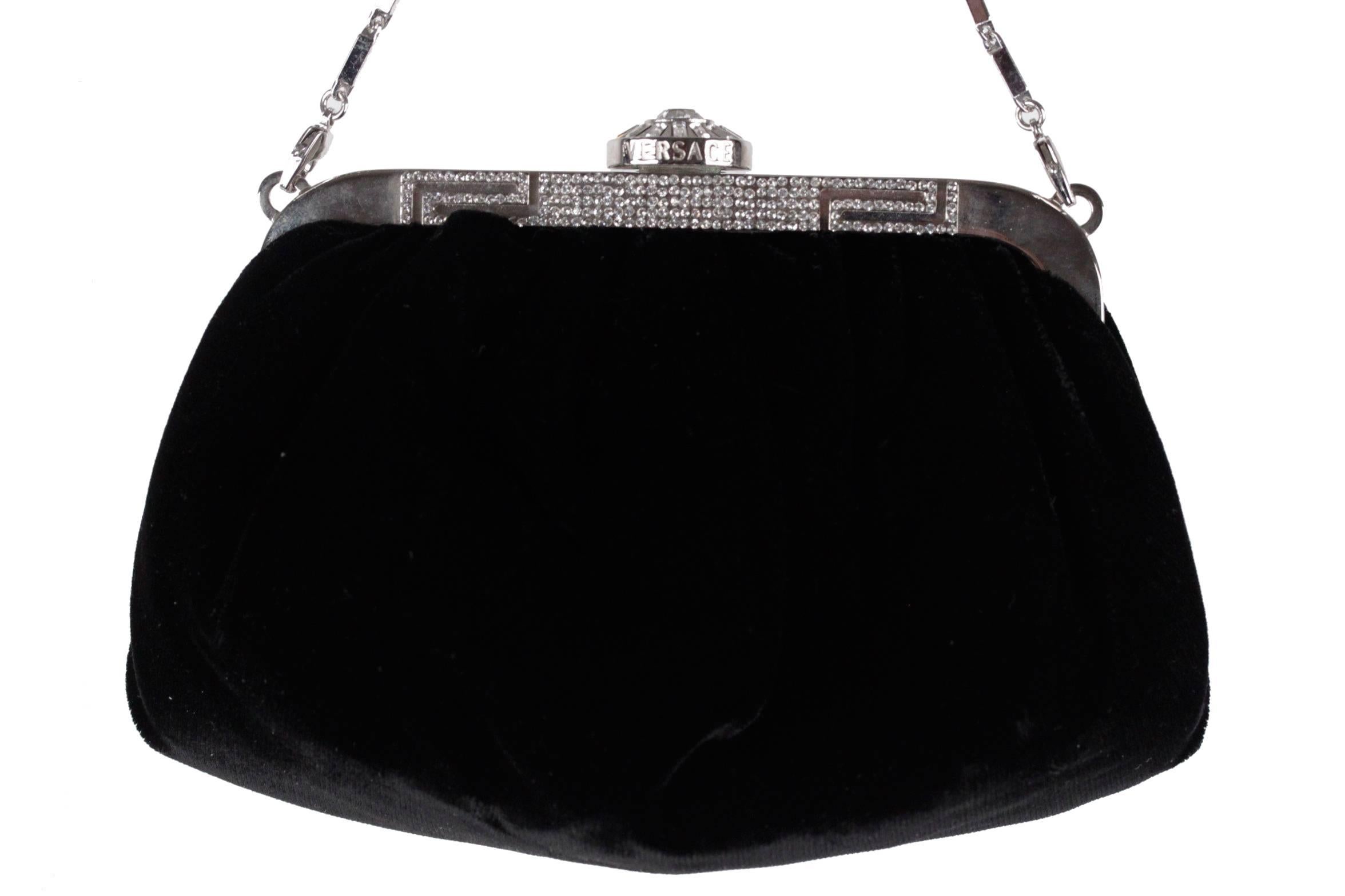 - VERSACE Black evening bag

- Silver metal frame embellished with rhinestones
- Clasp closure on top with rhinestones detailing
- Removable chain
- The purse is lined in a satin
- Approx. measurements: 3 1/2 x 8 x 4 inches - 8,9 x 20,3 x 10,2