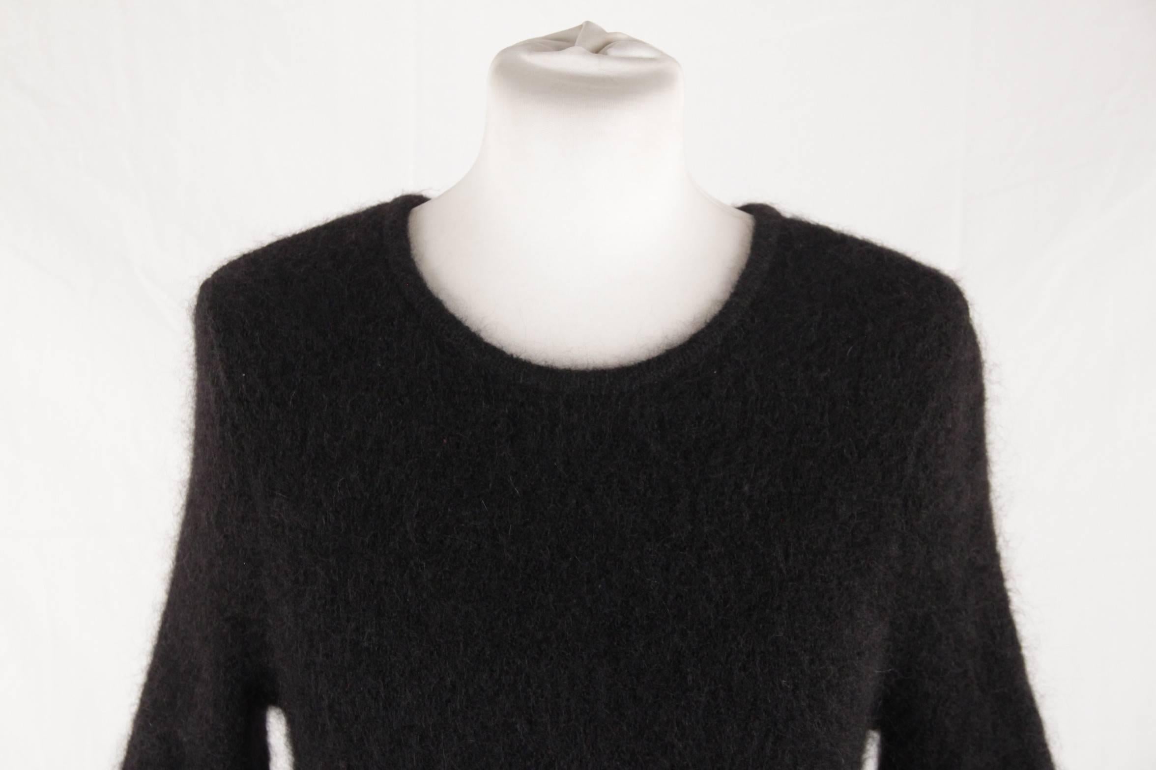 - Black Chanel long sleeve mohair dress
- From CHANEL 2009 Fall Collection
- Round neckline
- Undulating sheer knit cuffs and skirt hemlines.
- Asymmetrical hem
- Key hole with button closure at back
- 1 sparkly black button showing the Chanel