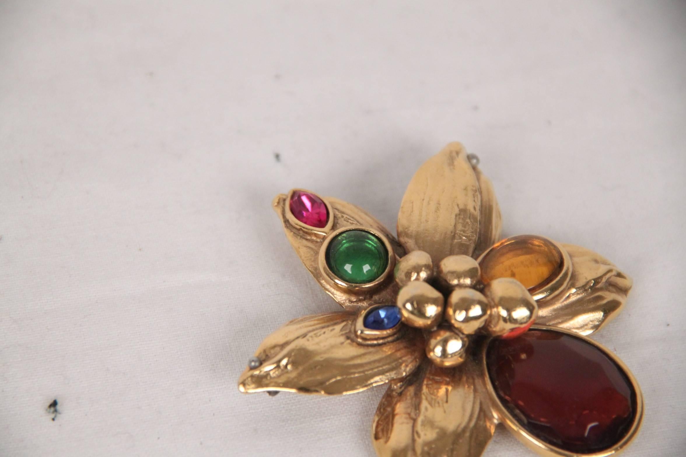 - Gold metal flower brooch

- Embellished with multi-colored glass stones

- Safety pin closure on the back 

- Width: 2 3/4 inch - 7 cm 

Logos / Tags: 'YVES SAINT LAURENT Rive Gauche - made in France' oval tab on its reverse 

Condition: B  :GOOD