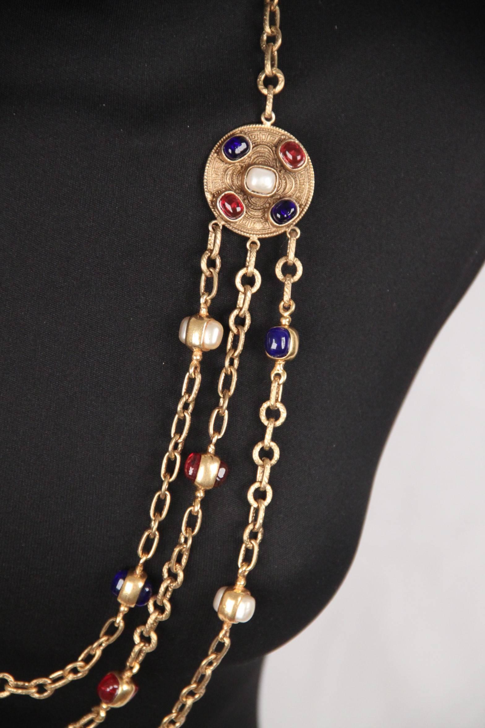 - Classic Vintage Chanel triple row chain necklace the 1984 
- Gold metal 3 rows chain decorated with blue, red and pearl-look double-sided glass paste cabochons
- Features 2 chiseled medallion decorated with glass paste cabochons in the same