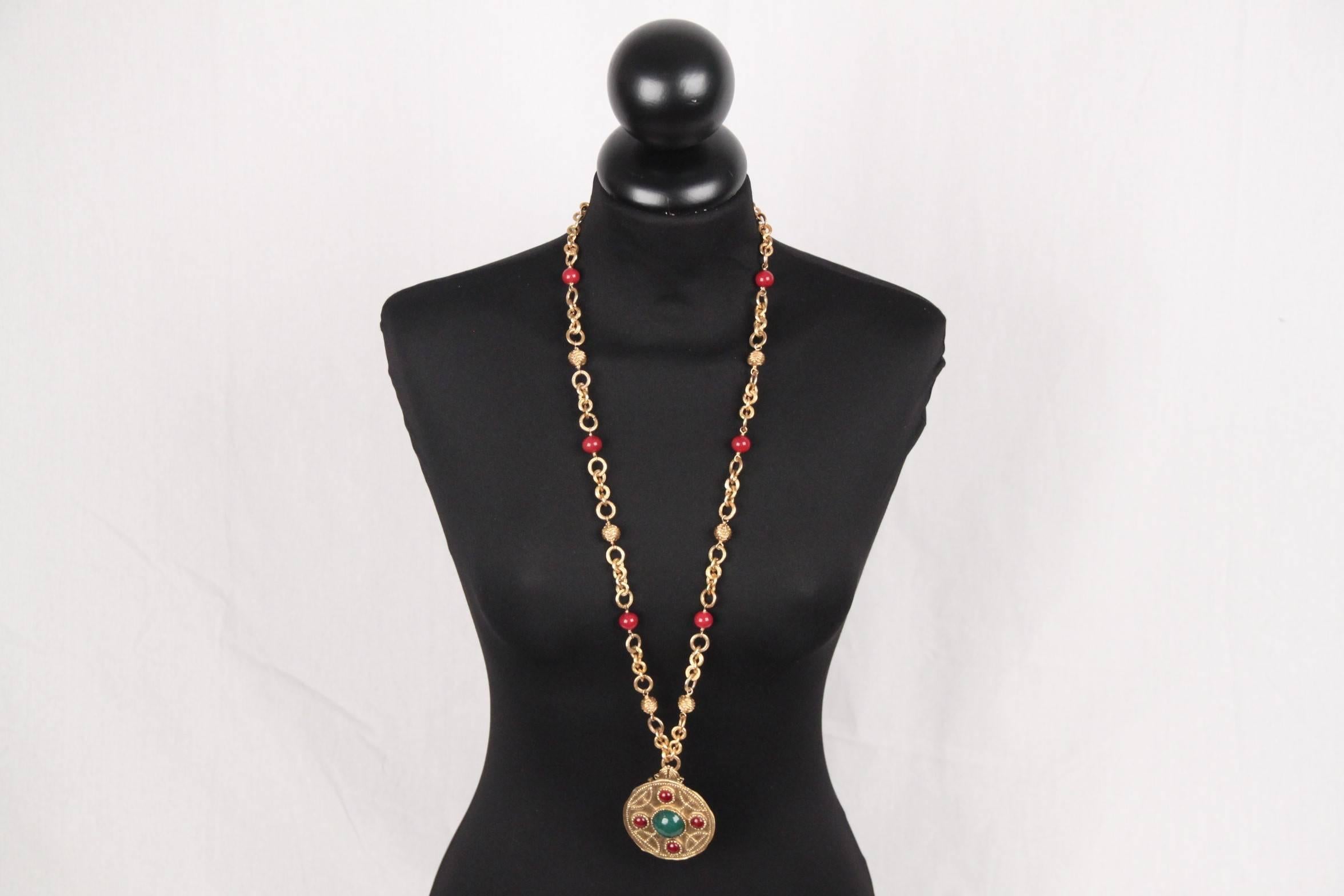 
- Period/ Era: Circa 1971-1980
- Long gold metal chain necklace featuring red round glass beads and chiseled gold balls
- 1 dangling round medallion pendant decorated with red & green cabochons
- The pendant can also be used as a brooch
-
