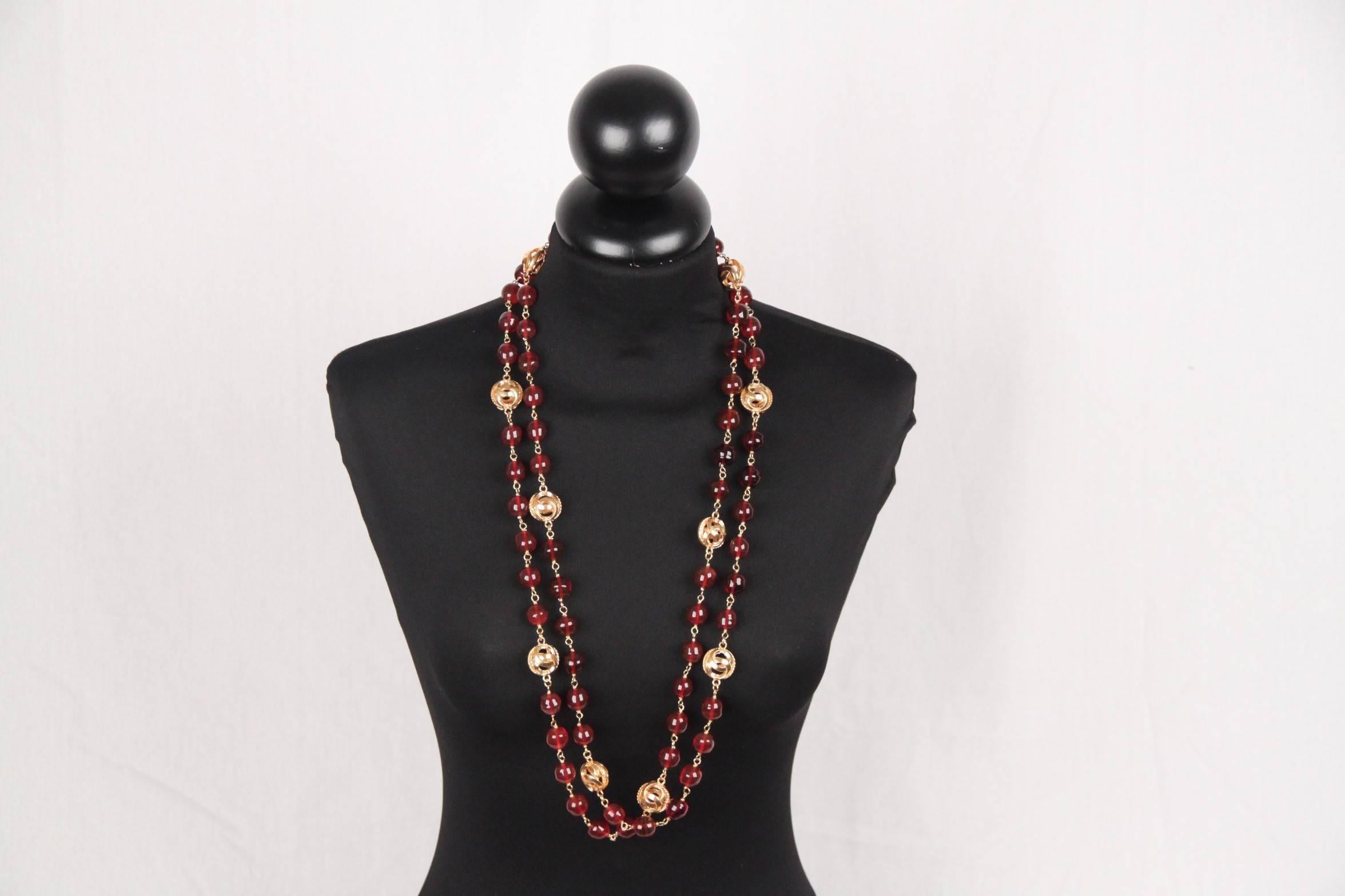 
- Period/ Era: Circa 1971-1980
- Extra-long necklace composed of burgundy round glass beads interlaced with gold metal CC logo openwork spheres
- Spring ring clasp
- Total lenght: 66.95 inches - 170 cm 
 
Logos & tag: 'C CHANEL R - CC - Made in