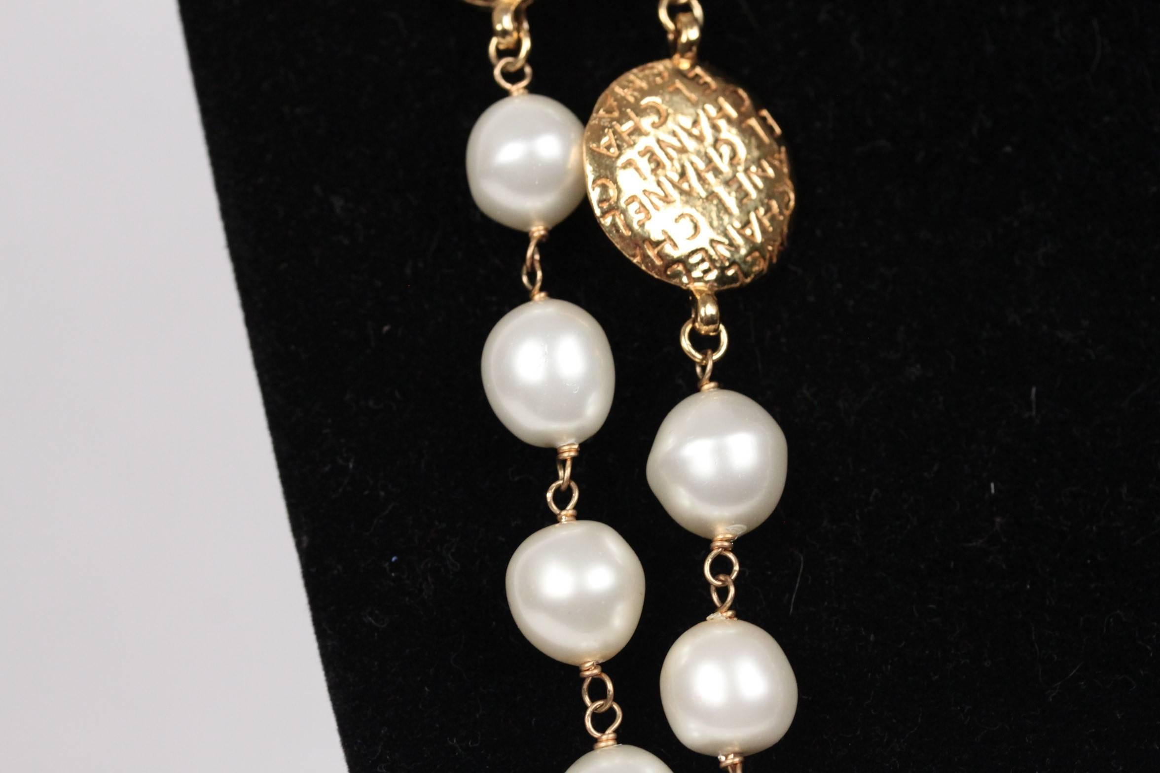 
- Period/ Era: Circa 1971-1980
- Extra-long necklace of glass pearl beads aternated with golden metal medals bearing the silhouette of Mademoiselle Coco on a side and engraved 'CHANEL signatures on the other
- Spring ring clasp
- Total lenght: