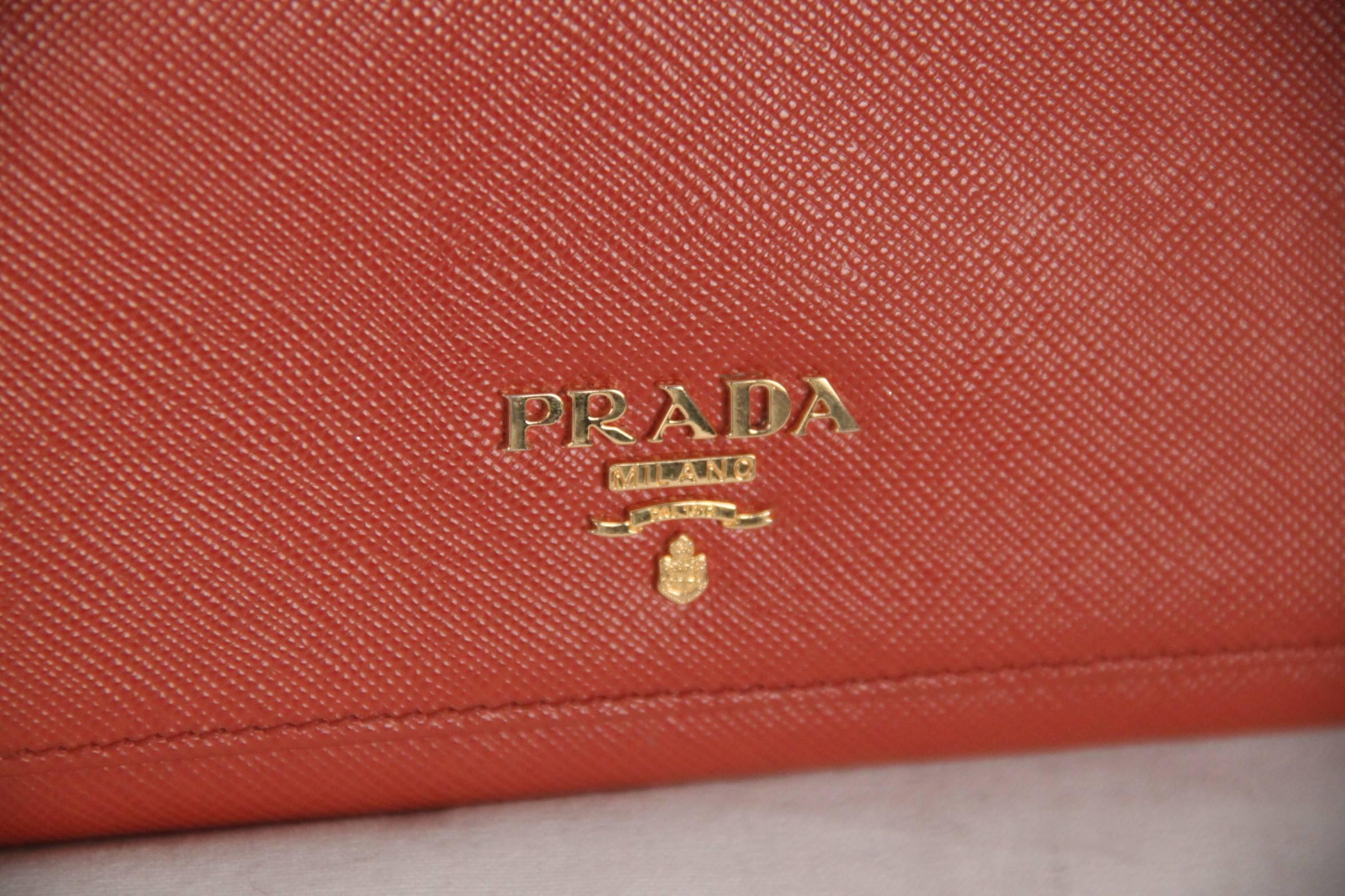 

- Leather flap wallet in orange color (official PRADA color is 'RAME') by PRADA
- Saffiano Leather
- Mod. 1M1132
- Gold-plated hardware
- Metal lettering logo
- Snap closure
- 10 credit card slots
- One coin compartment with zipper closure
- 2