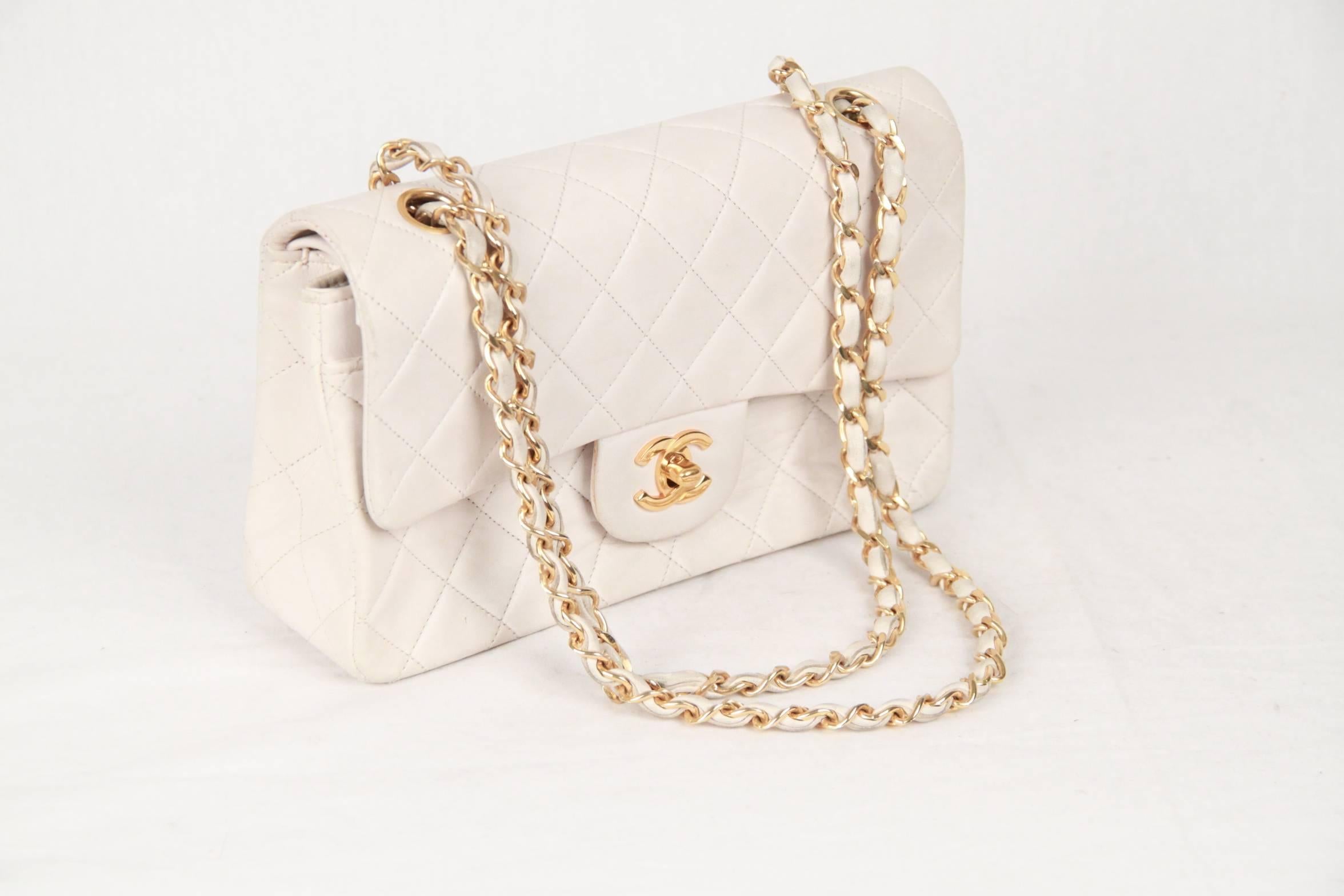 Chanel Classic Quilted Double Flap Bag in White color. Features double 'CC' turn lock closure and double flap interior. Gorgeous gold metal strap; can be worn on the shoulder with double strap or lengthen to wear with one single strap. Features back