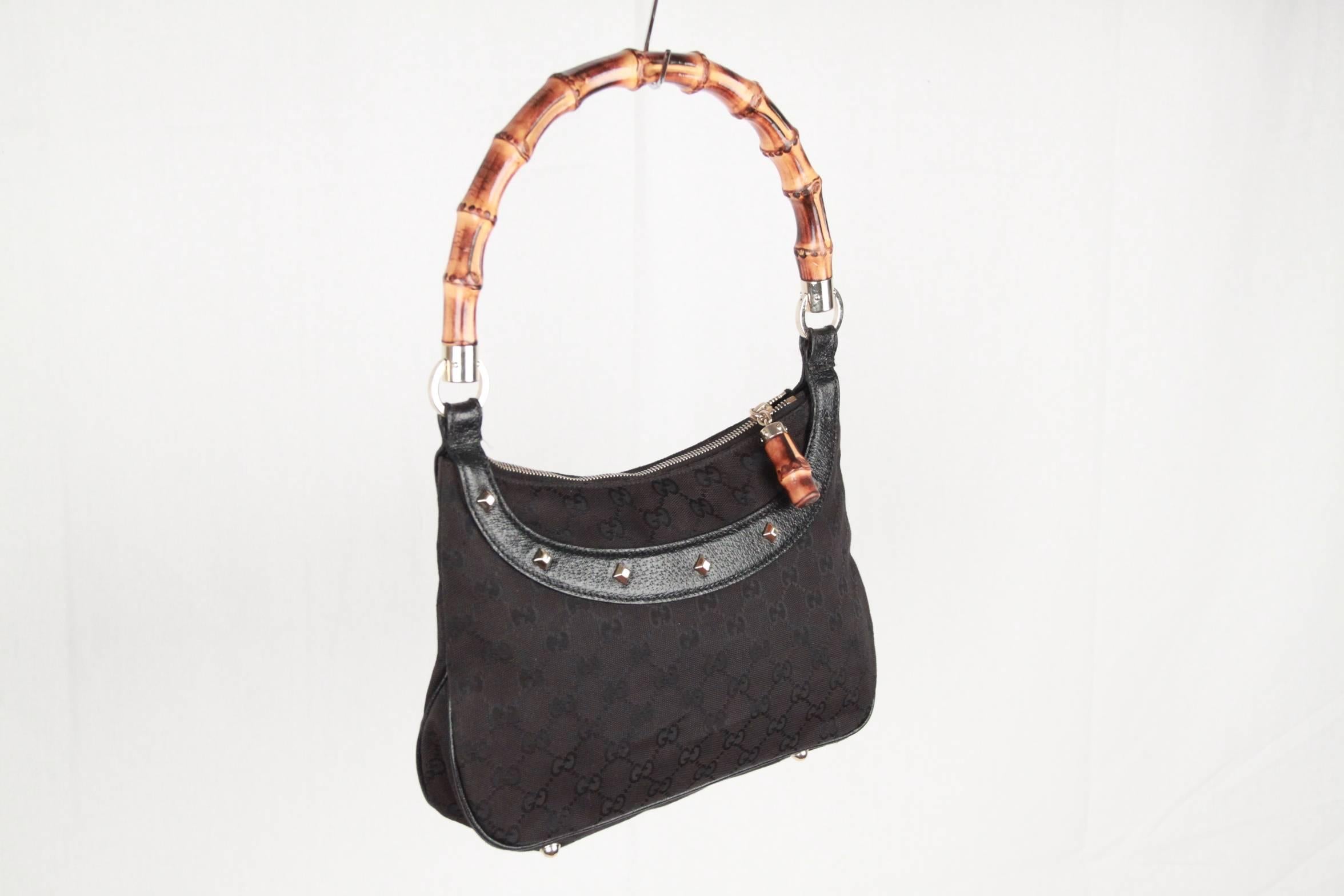 
Gucci small hobo crafted in black GG monogram canvas with black leather trims. This small hobo bag features a  bamboo handle,  upper zip closure with bamboo zuipper pull, gold-tone studs detailing, and protective base studs. Black fabric-lined