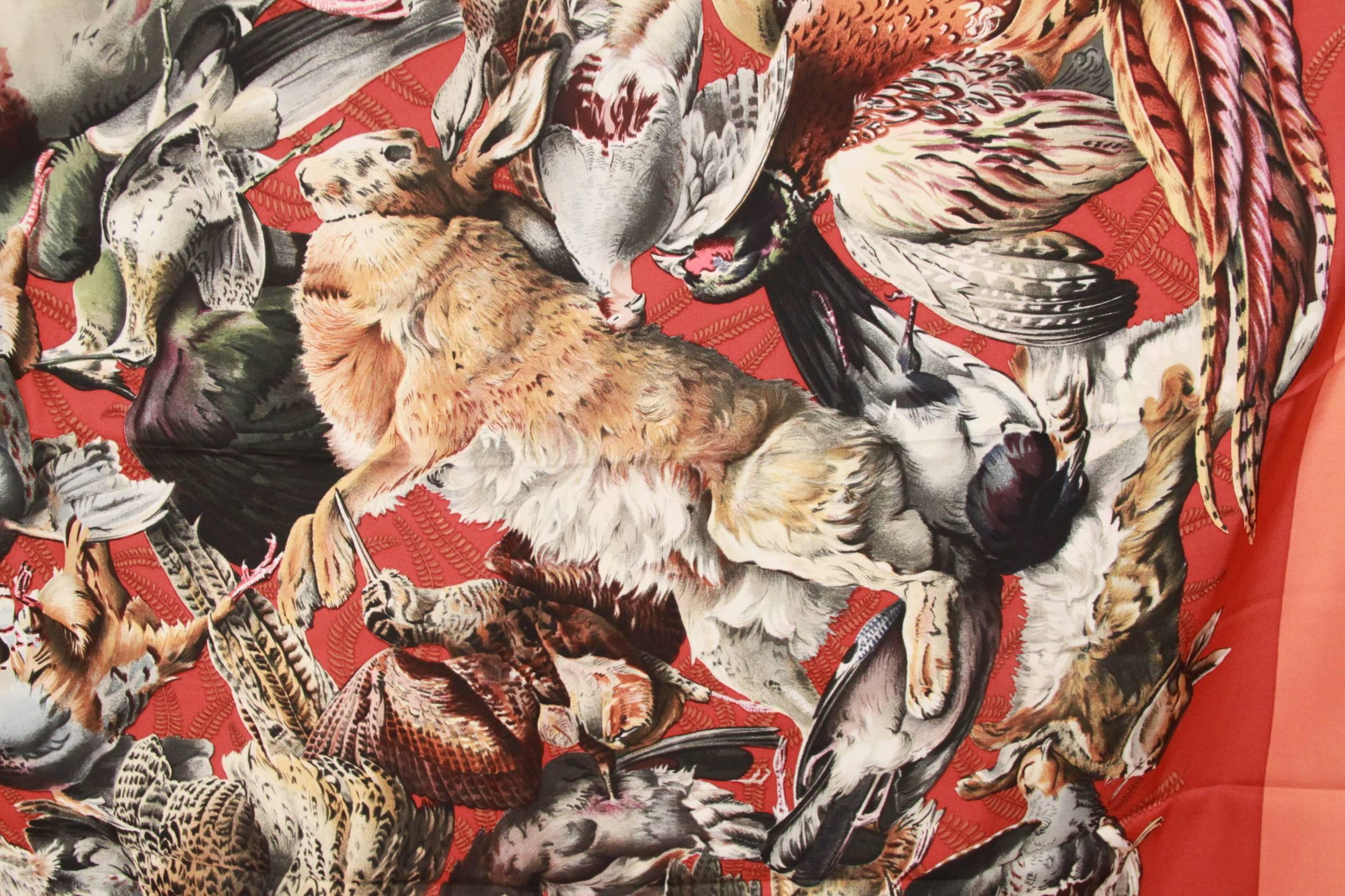 HERMES vintage gorgeous "GIBIERS" print silk scarf. Designed by HENRI DE LINARES and first issued in 1966. Opulent design of pheasants, rabbit, and hunting game on red background and orange border. Hand rolled edges. Made in France

Logos
