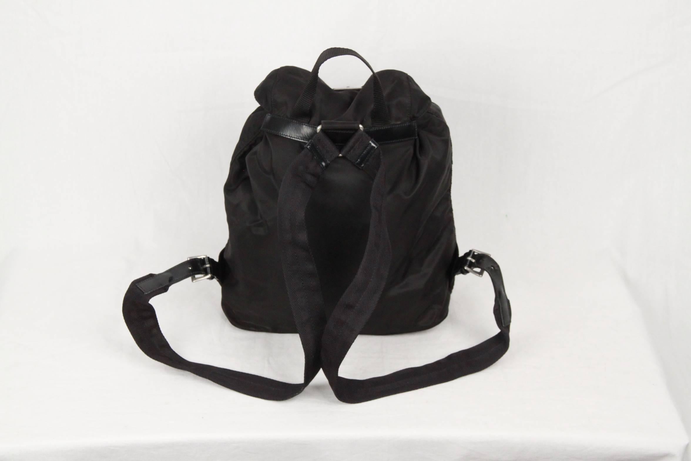 - Nylon avec matériel argenté.
- Sangles réglables.
- Fermeture supérieure avec cordon de serrage.
- Haut à rabat bouclé avec plaque logo triangle PRADA
- Poche extérieure zippée sur le devant.
- Doublure en tissu PRADA avec 1 poche latérale zippée