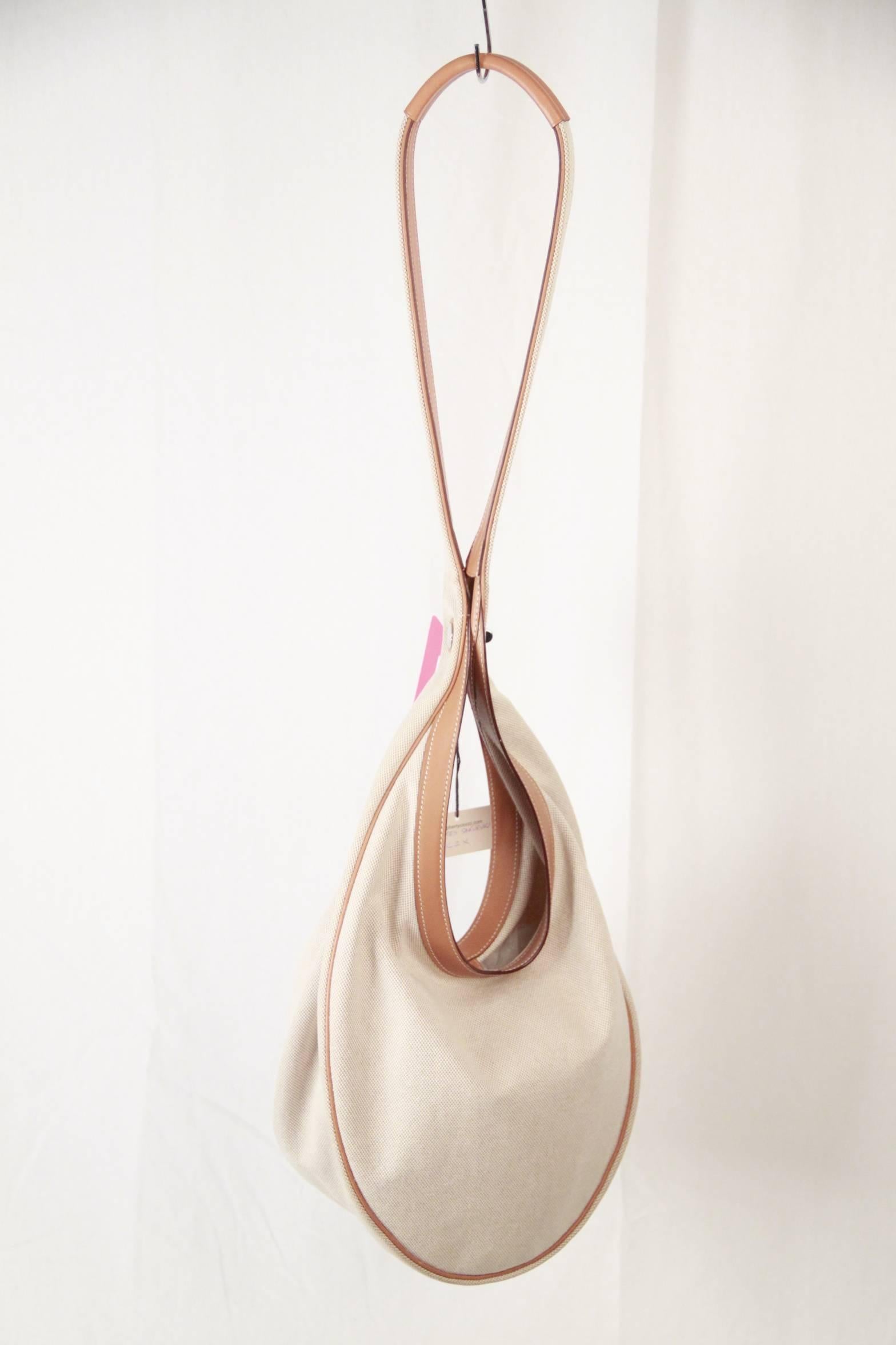 - 'Sakuruko' shoulder bag by Hermes, crafted in beige canvas 
- Flat leather shoulder bag
- Palladium hardware
- Snap closure
- Measurements: 10 x 11 x 4.5 inches - 25,4 x 28 x 11,5 cm 
- Shoulder Drop: 21 inches - 53,3 cm

Logos / Tags: 'HERMES
