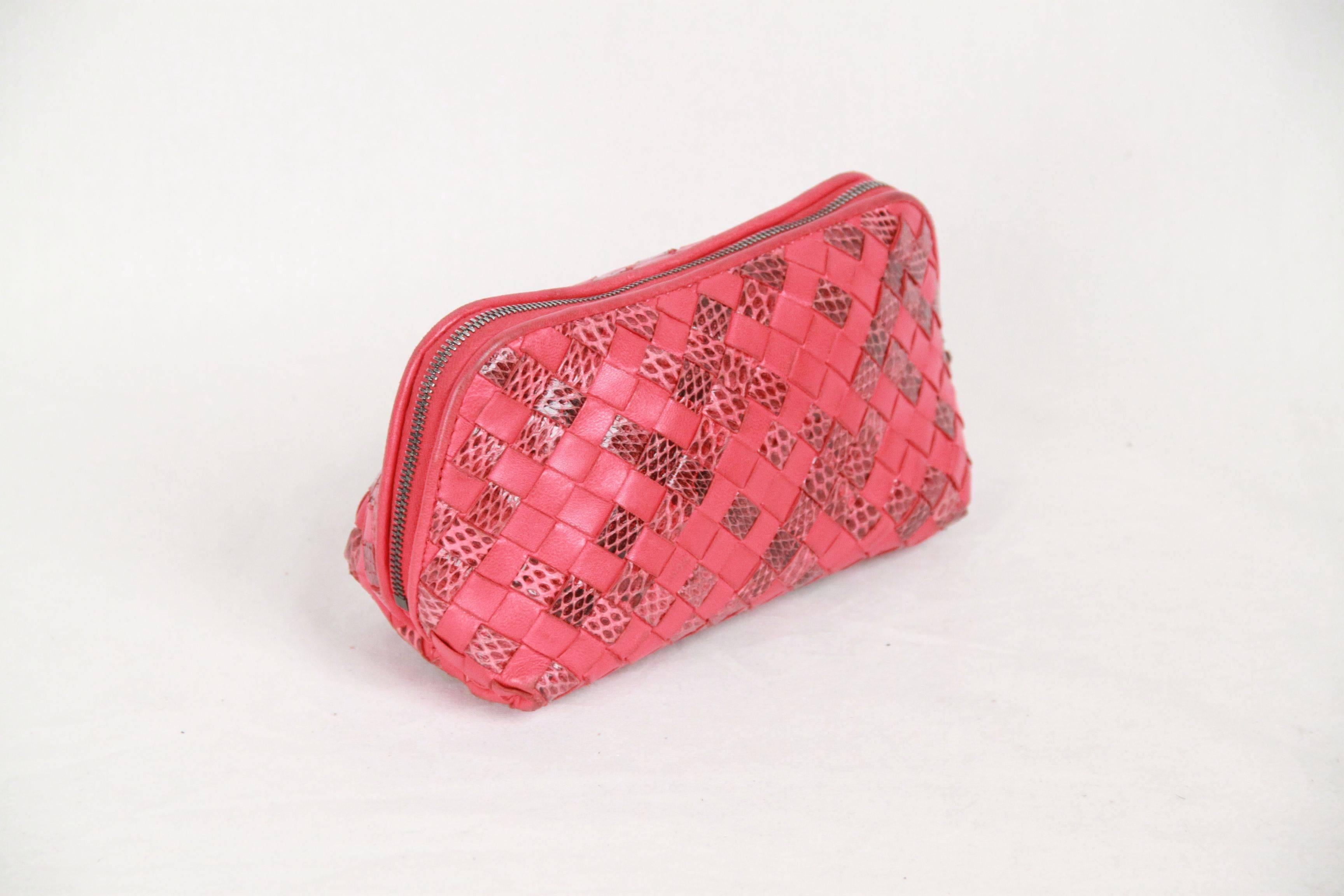 Bottega Veneta's red cosmetic case is handcrafted of soft red leather and snakeskin leather woven in the house's signature Intrecciato pattern. A hallmark of the Italian brand, this pattern was created in the 1960s to increase the strength and