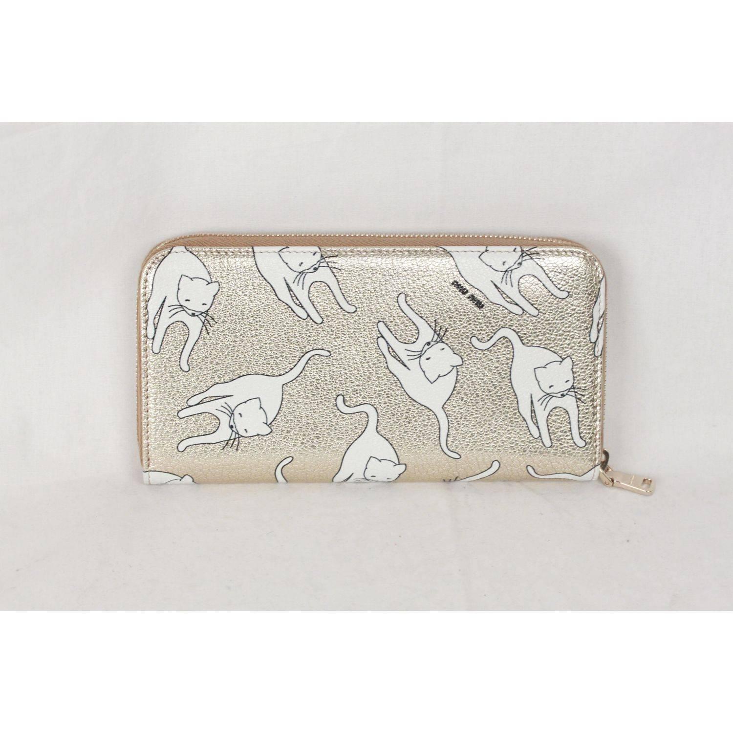 - Light Gold-tone leather wallet with white Cat Print (DUCHESSE) by MIU MIU
- classic continental shape
- Gold metal hardware
- Metal lettering logo on the front
- Zipper closure
- 12 credit card slots
- 3 main bill comartments
- 1 coin compartment
