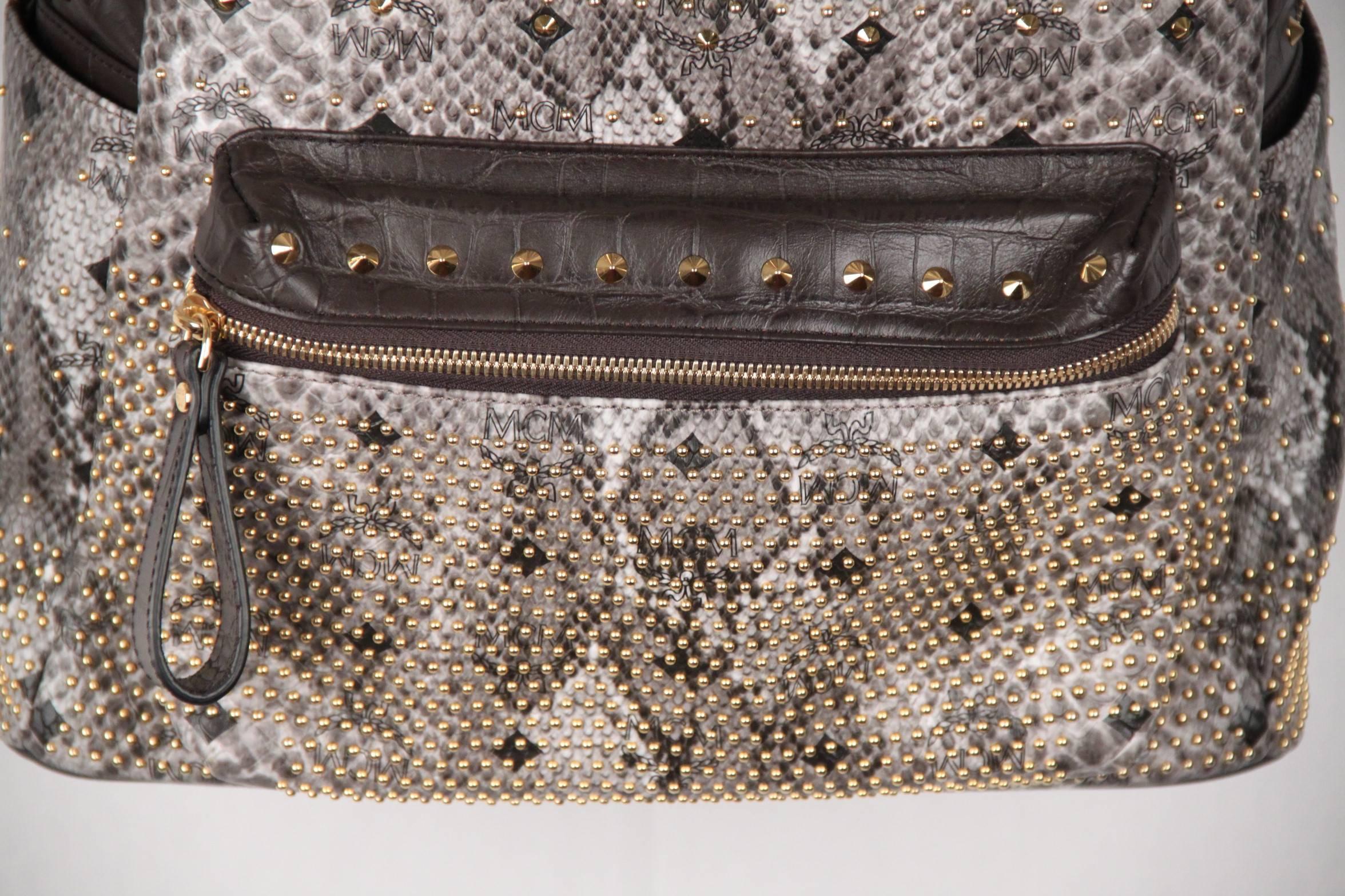 - Python visetos coated canvas body Limited Edition - Gray - Gold tone hardware - Single top handle, double adjustable back straps - Zip around closure - 1 zipper compartment on the front & 2 slip pockets on the sides - Gold metal Stud detailing -
