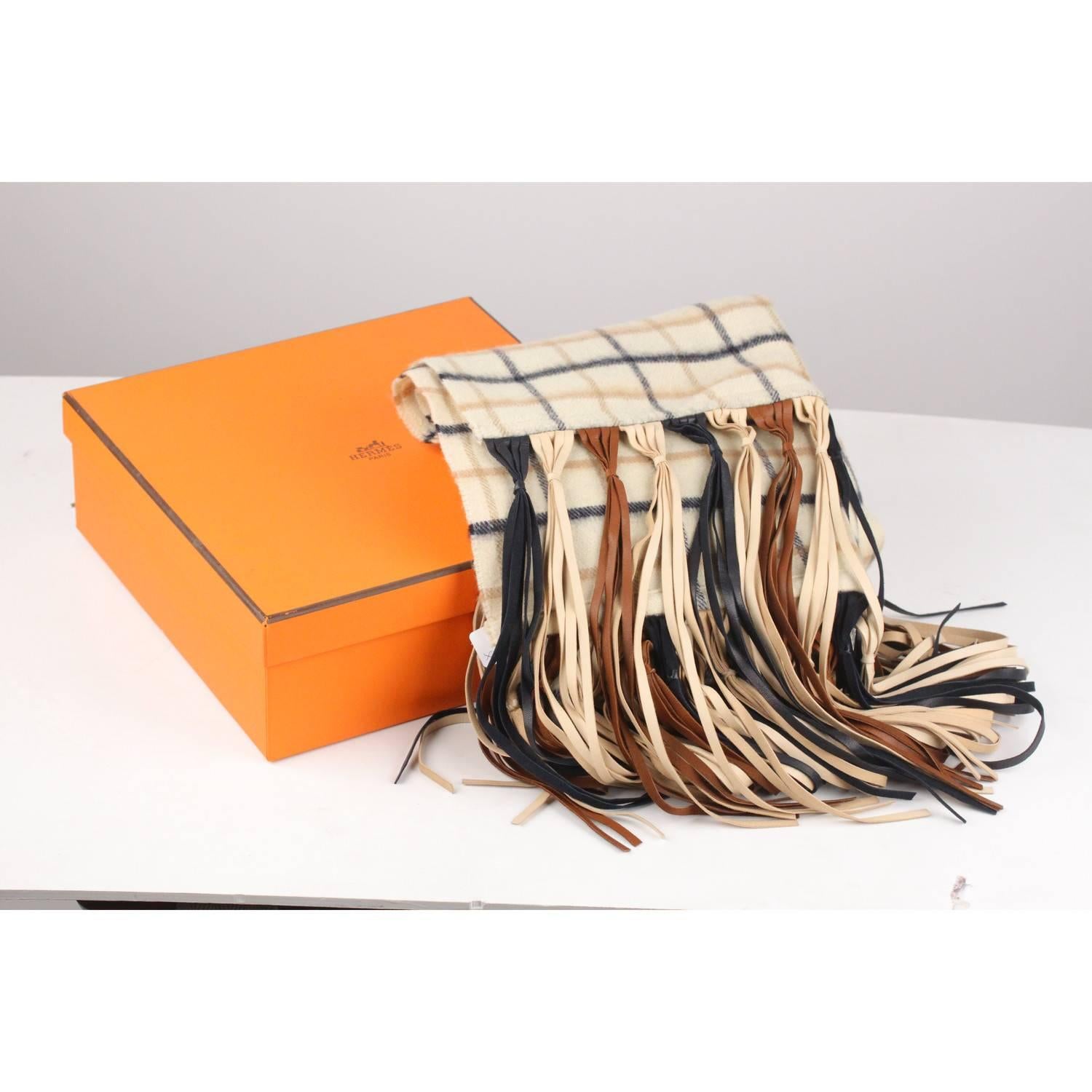 Beautiful Hermes vintage long scarf in cashmere and wool fabric. Checkered pattern on beige background. Multicolored long, knotted leather fringe on either end. Comes with HERMES box. Total lenght: 74 inches - 187 cm (excluding fringes)