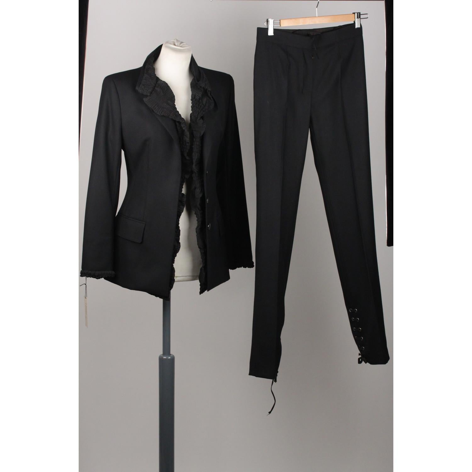 - Pant Suit by YVES SAINT LAURENT Rive Gauche
- Black color
- Ruffle detailing on the front
- Button closure on the front
- Trousers with concelaed hook and bar and zip closure on the front
- Lace-up detailing at the end of the legs
- Composition: