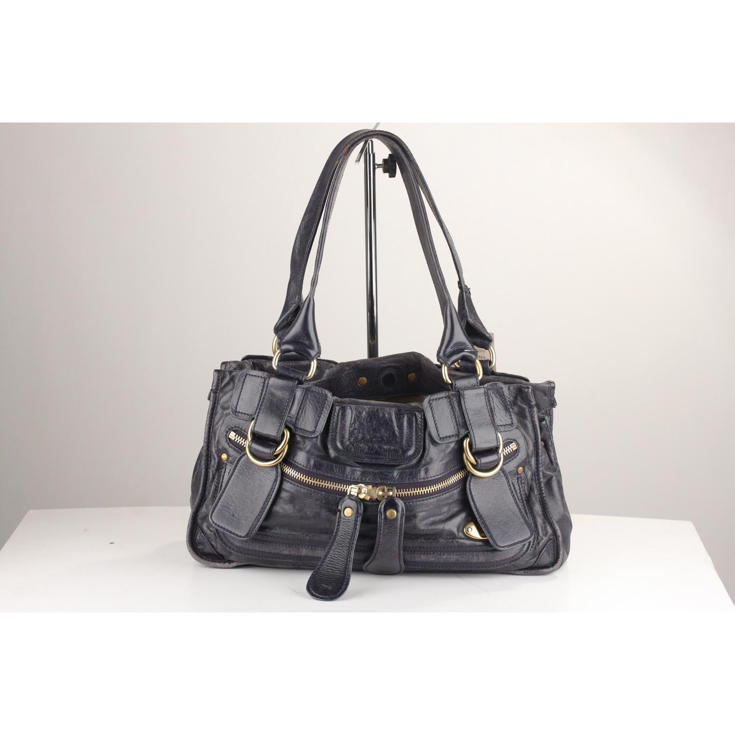 - Chloé Bay Bag shoulder bag
- Crafted in navy blue leather with a light distressed finish
- 2 front zip pockets and 1 hidden pocket on the front
- Double top handles
- Magnetic concealed button closure
- 2 main sections with 1 middle zipper