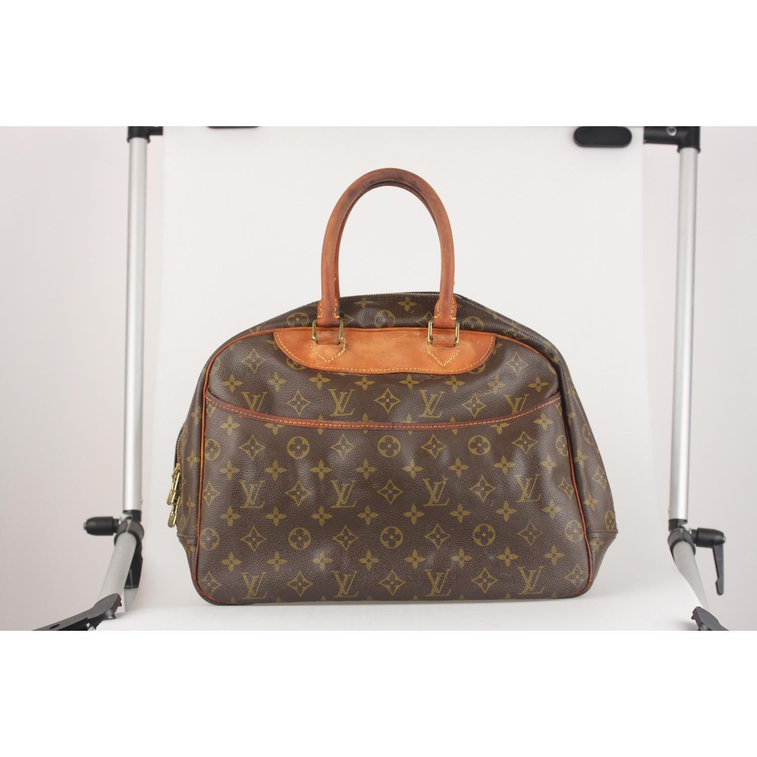 Vintage Louis Vuitton DEAUVILLE Bag crafted in timeless monogram canvas with genuine leather trim and handles. Upper zipper closure. Two exterior open pockets. Beige washable lining with 4 open pockets, 1 elastic strap to hold bottles and cosmetics