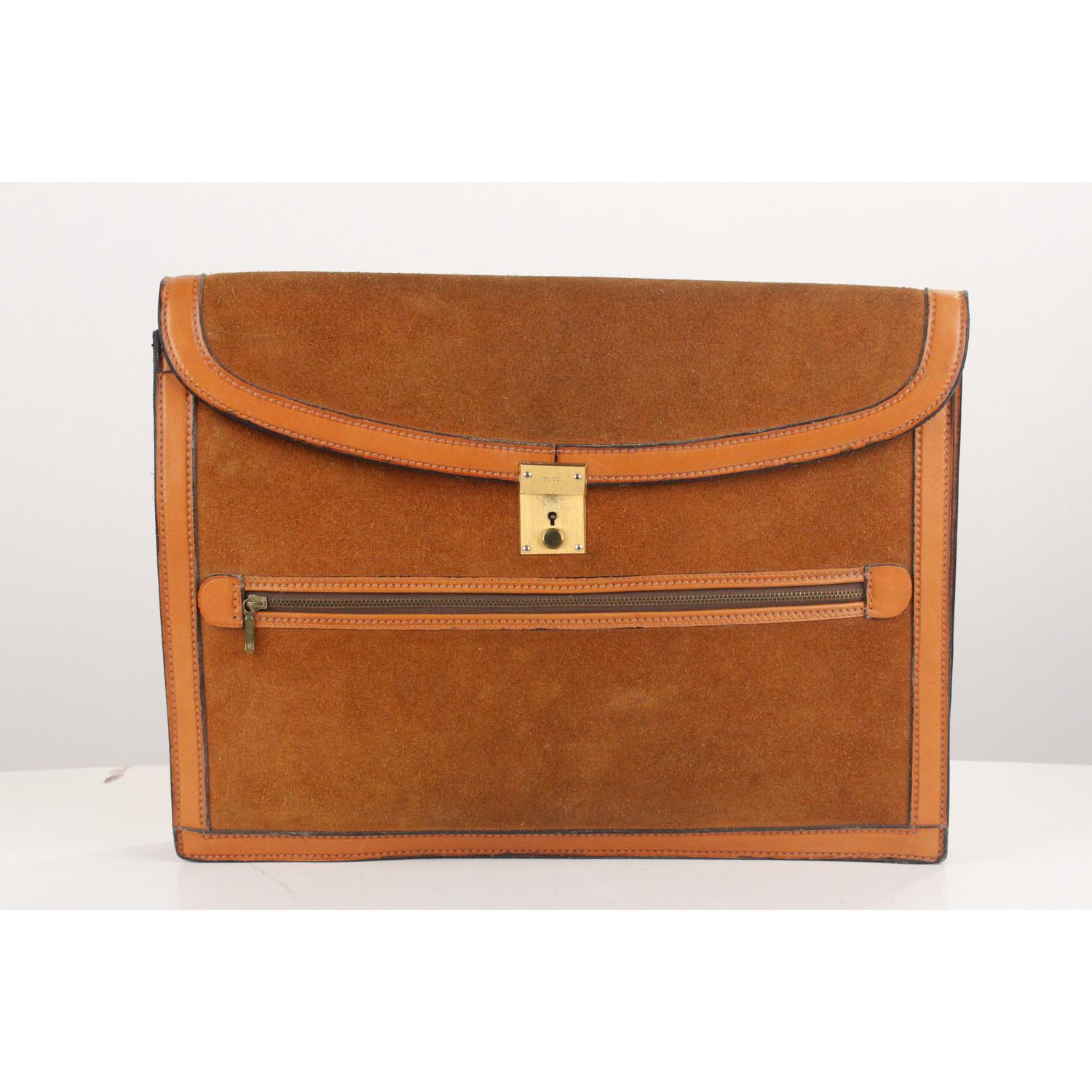 - Vintage Gucci tan suede leather flap  portfolio - Flap with key closure (key is included) - GUCCI signature engraved on the closure - 1 front zip pocket - 2 main compartments  - Leather and canvas lining  - 'Made in Italy by GUCCI' embossed inside.