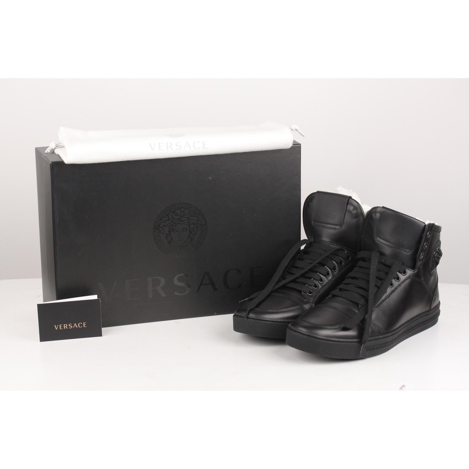 Versace high-back sneakers, made of black leather. Lace-up fastening. VERSACE logo on the tongue. Medusa head on the side. Black rubber sole with Greek pattern. Size 43. Made in Italy