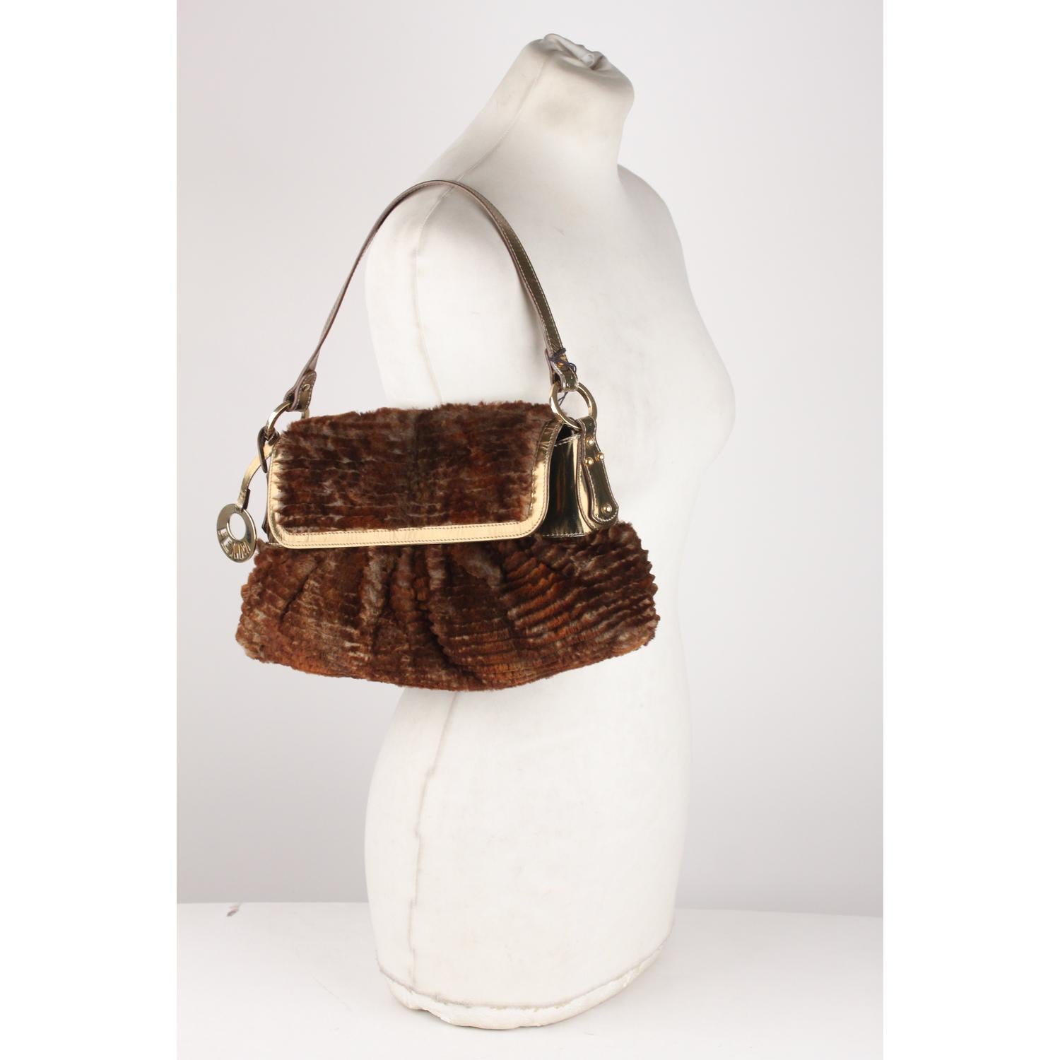 - Fendi 'Chef' Shoulder bag
- Brown lapin rabbit fur with metallic leather trim
- Gold metal Fendi logo charm dangling from one side
- Flap with magnetic button closure
- Orange satin lining
- 1 side open pocket inside 

Logos & tags: 'FENDI - made