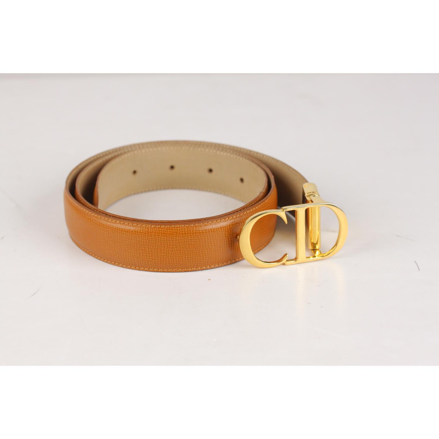 Christian Dior tan leather reversible belt. Gold metal CD logo buckle. Total lenght (Buckle included): 39.25 inches - 99,6 cm. From buckle to first hole (Max circumference): 36 inches - 91,5 cm. From buckle to last hole (Min circumference): 30