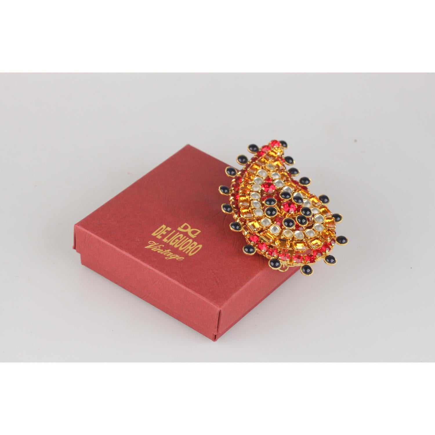 Rare 1980s Haute Couture Brooch created by Gianni De Liguoro for Rocco Barocco. Paisley design. Deep red and orange faceted crystal rhinestones and white and black glass cabochons. Gold-tone brass setting with safety pin closure on the back. De