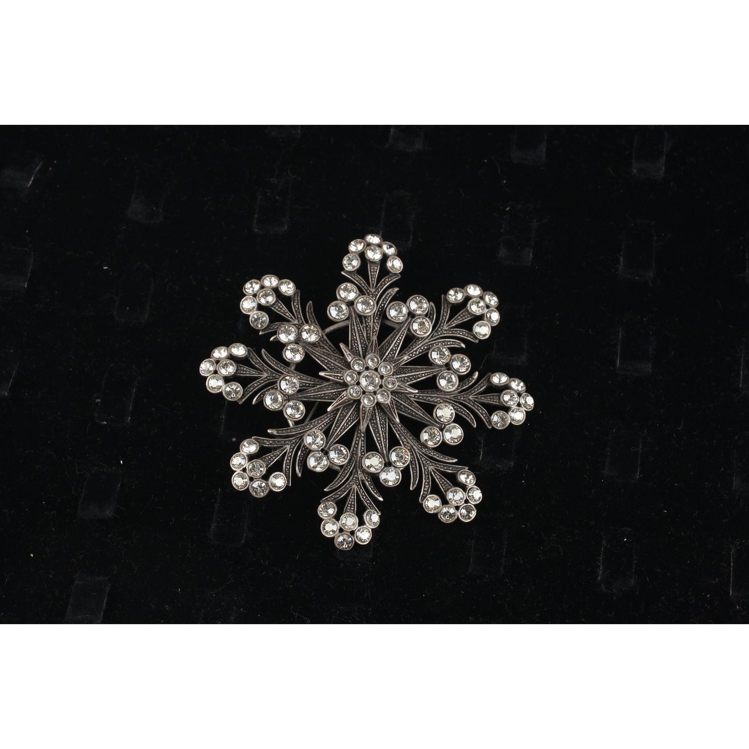 Haute Couture Snoflake Brooch created by Gianni De Liguoro in the 2000s. Antiquated silver metal decorated with white crystal rhinestones. Safety pin closure on the back. De Liguoro signature engraved on the back. Max, Width: 3.5 inches - 8,8 cm