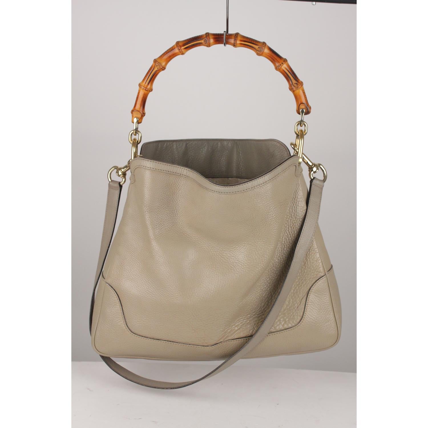 Gucci 'Diana' hobo bag, crafted in taupe genuine leather with bamboo loop handle. Detachable shoulder strap. Gold metal hardware. GG - GUCCi monogram fabric lining with 1 side zip pocket and 2 side open pockets. ' GUCCI - Made in Italy' tag inside