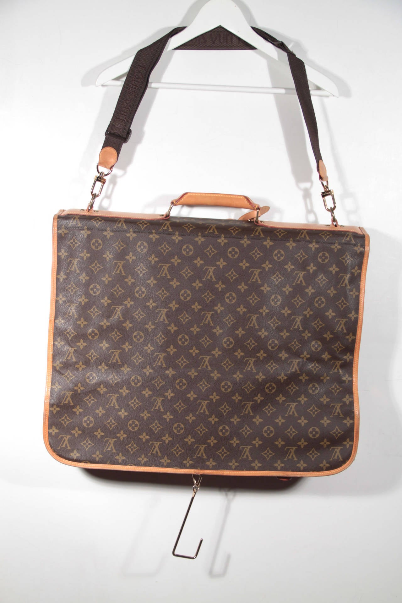 - Brown Monogram Canvas

- Foldable design with clasp on bottom sides for securing bag when folded

- Zip around closure

- Removable and adjustable shoulder strap and leather top carrying handle

- Removable leather address holder

-