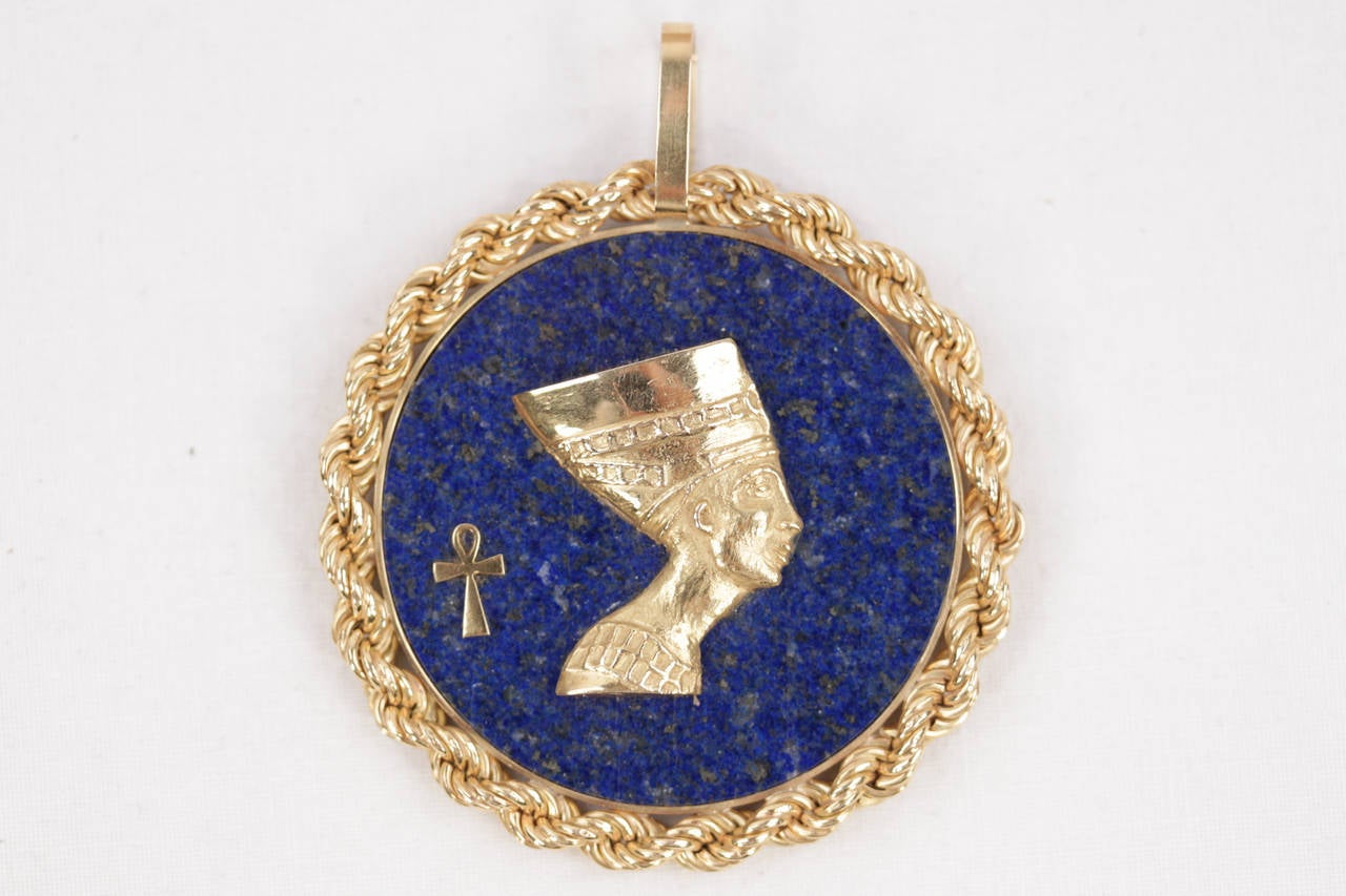 - Vintage Gold and lapis round pendant hand made early 70'
- Yellow gold 18k (marked inside the loop)
- Beautiful ancient Egyptian Queen Nefertiti on the front 
- Approx. diameter: 5,5 cm - 2 inches
- Weight: 26,3 gr

Condition: EXCELLENT CONDITION: