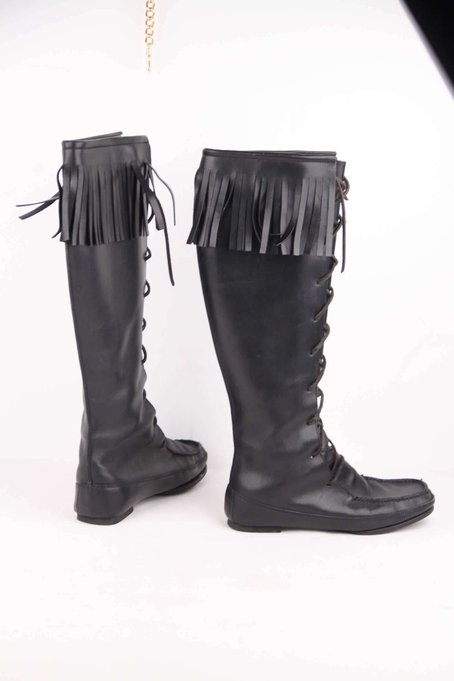 - Gucci black leather knee high pull-on moccasin style boots

- Lace-up front

- Fringed detail on the leg opening

- Leather outer and inner

- 'Vibram' rubber heel and partial rubber sole

- Size: 37 1/2 C (The size shown for this item