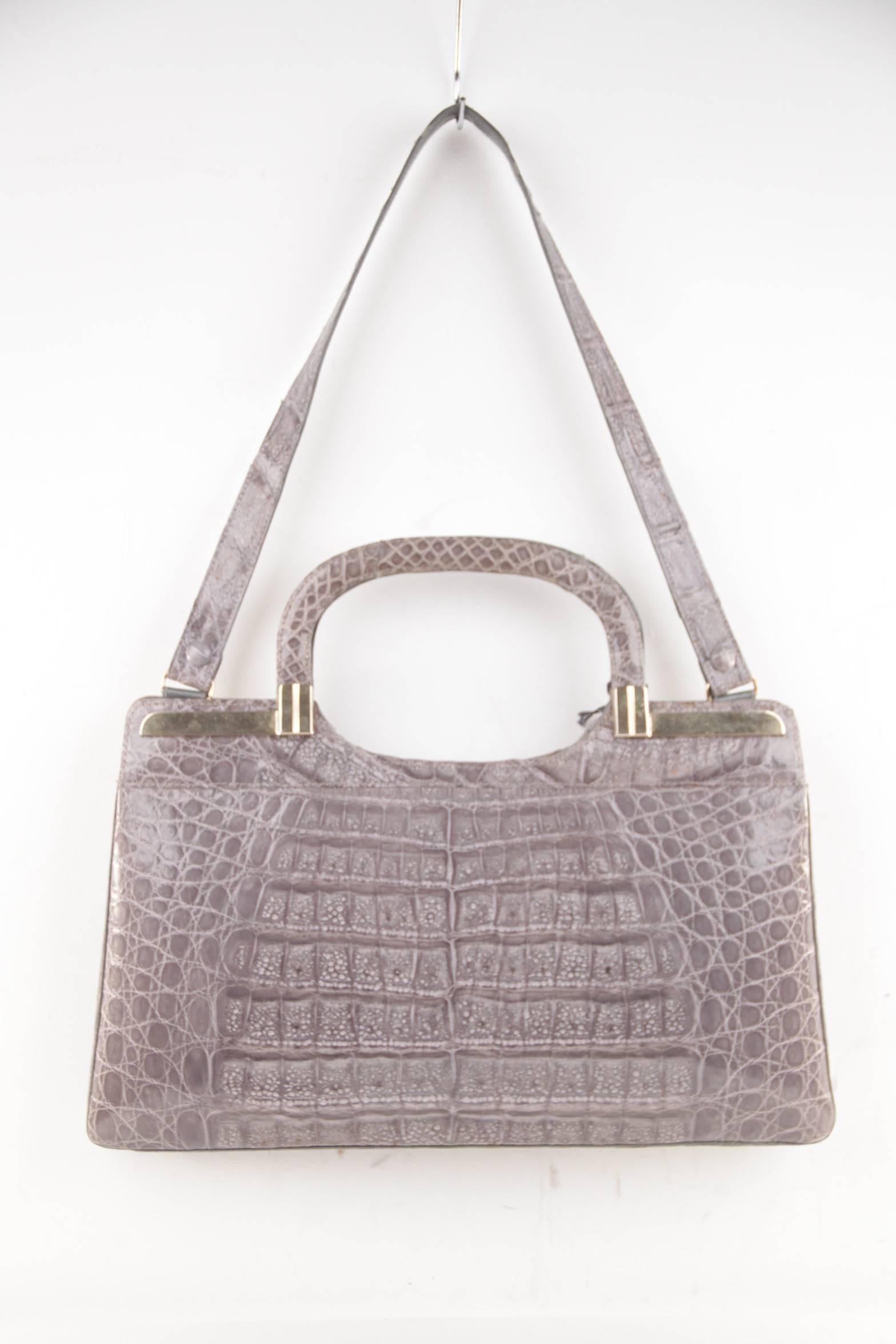 
- Gray Crocodile leather

- Gold metal hardware

- Top handles

- Double button closure on top

- Gray lining

- 1 side zip pocket & 1 side open pockets

- Approx. measurements: 8 1/2 x 14 1/2 x 1 1/2 inches - 21,5 x 36,8 x