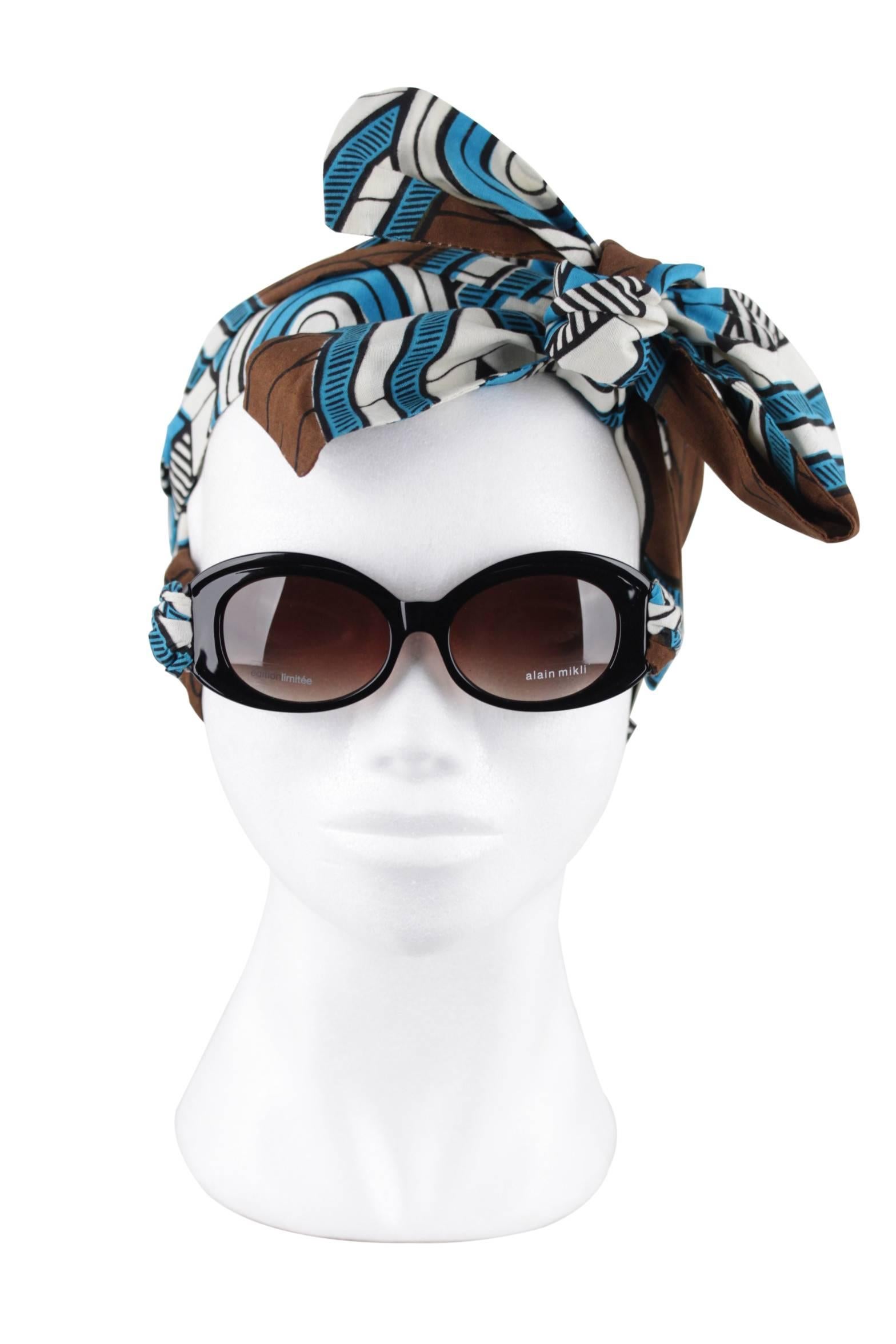 - Unique Alain Mikli 'Imany' A01425 sunglasses - Limited Edition Collection (030/090)
- Mod. A01425 101K - 52/17 - 140
- 'lunette-foulard': removable African wax print scarfs dresses up the temples of an oval shaped frame
- Full rim black oval