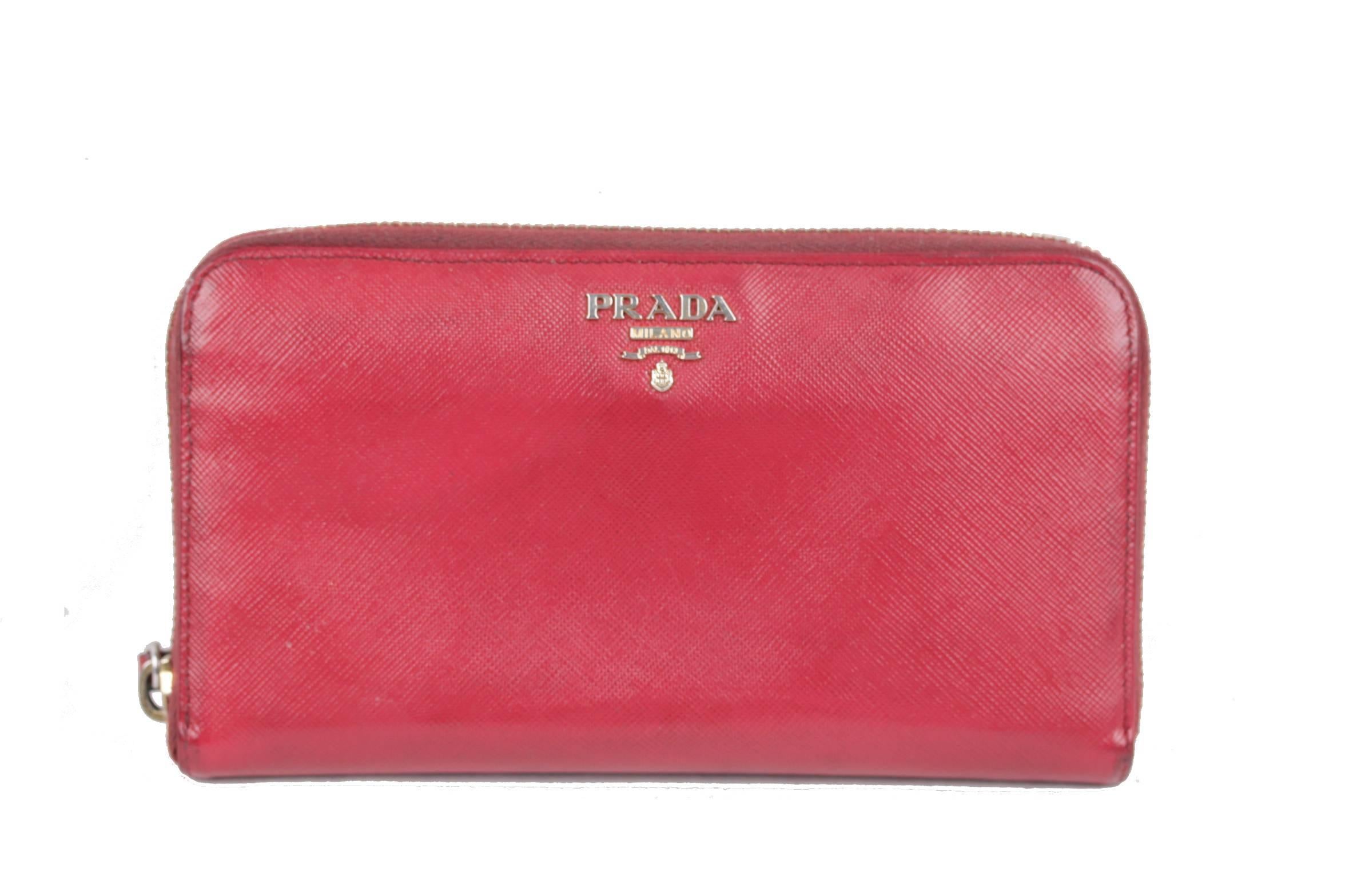  - Made of Red Saffiano Leather

- Gold metal Prada logo lettering

- Wrap-around zipper

- 8 credit card slots & 2 open pockets

- 2 bill compartments & 1 middle zip compartment for coins

- Leather & nylon lining

- Stores your credit cards,
