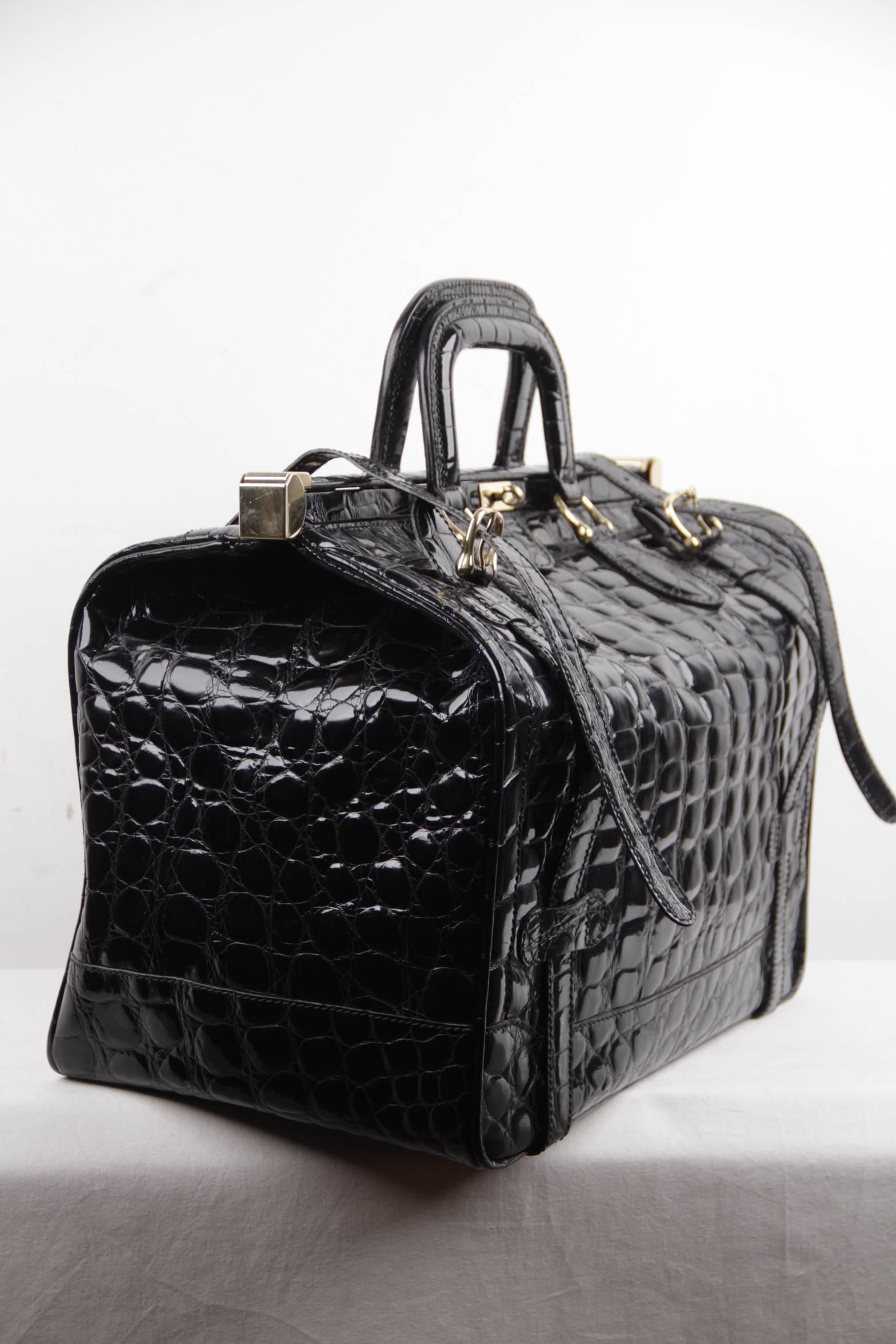 
- Crafted in black patent leather

- Embossed crocoile pattern

- Double clasp closure and front twist closure

- Additional double strap closure

- 5 bottom feet

- Beige canvas lining

- 1 side zip pocket inside

- Gold metal hardware

- Approx.