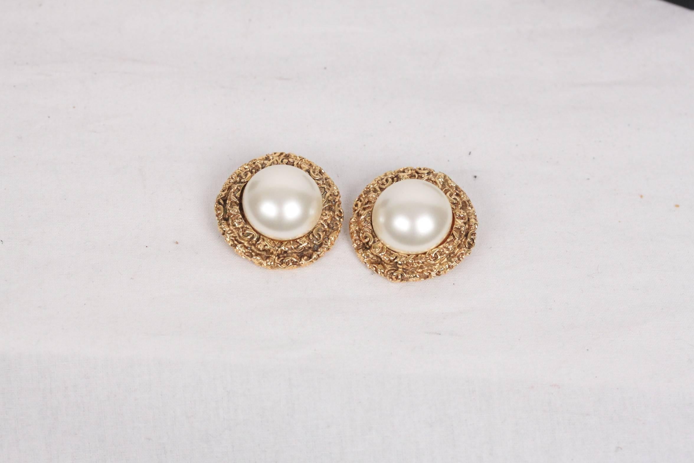 - Gorgeous vintage CHANEL earrings 
- Faux Pearl and gold metal bezel with embossed small CC Logos 
- Clip-on earrings
- Signed ' C CHANEL R - 93 CC A - MADE IN FRANCE' in a oval mark. 
- Diameter: 1 1/4 inches - 3,2 cm 
- Comes with original CHANEL