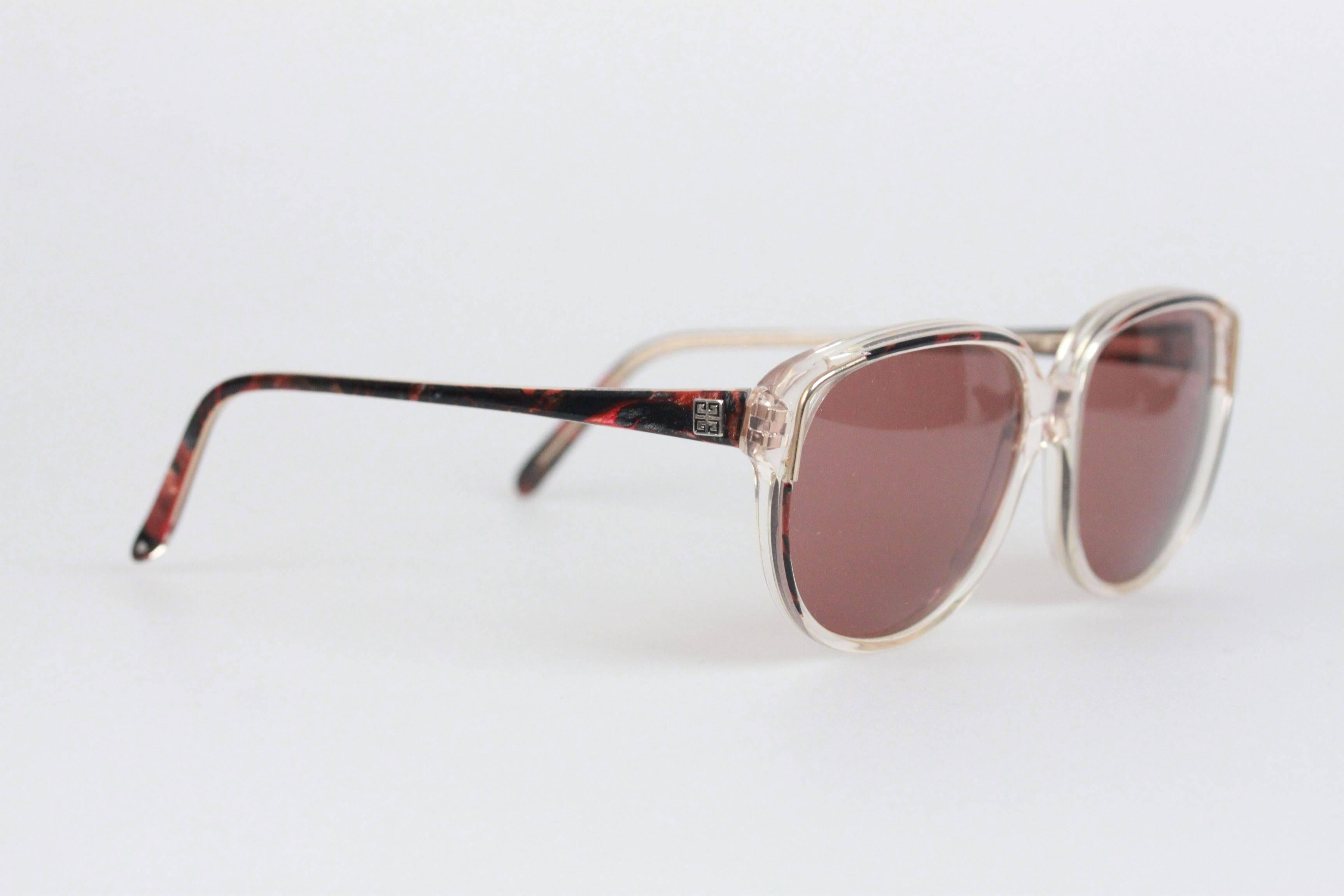 - Mod. G 8912
- Period/Era: 1980s
- Red Marbled / Clear plastic frame
- GIVENCHY logo on temples
- 100% UV protection gray lenses
- Made in France

Measurements:
- TEMPLE LENGTH: 132 mm
- TEMPLE TO TEMPLE - MAX WIDTH: 126 mm
- EYE / LENS WIDTH: 53