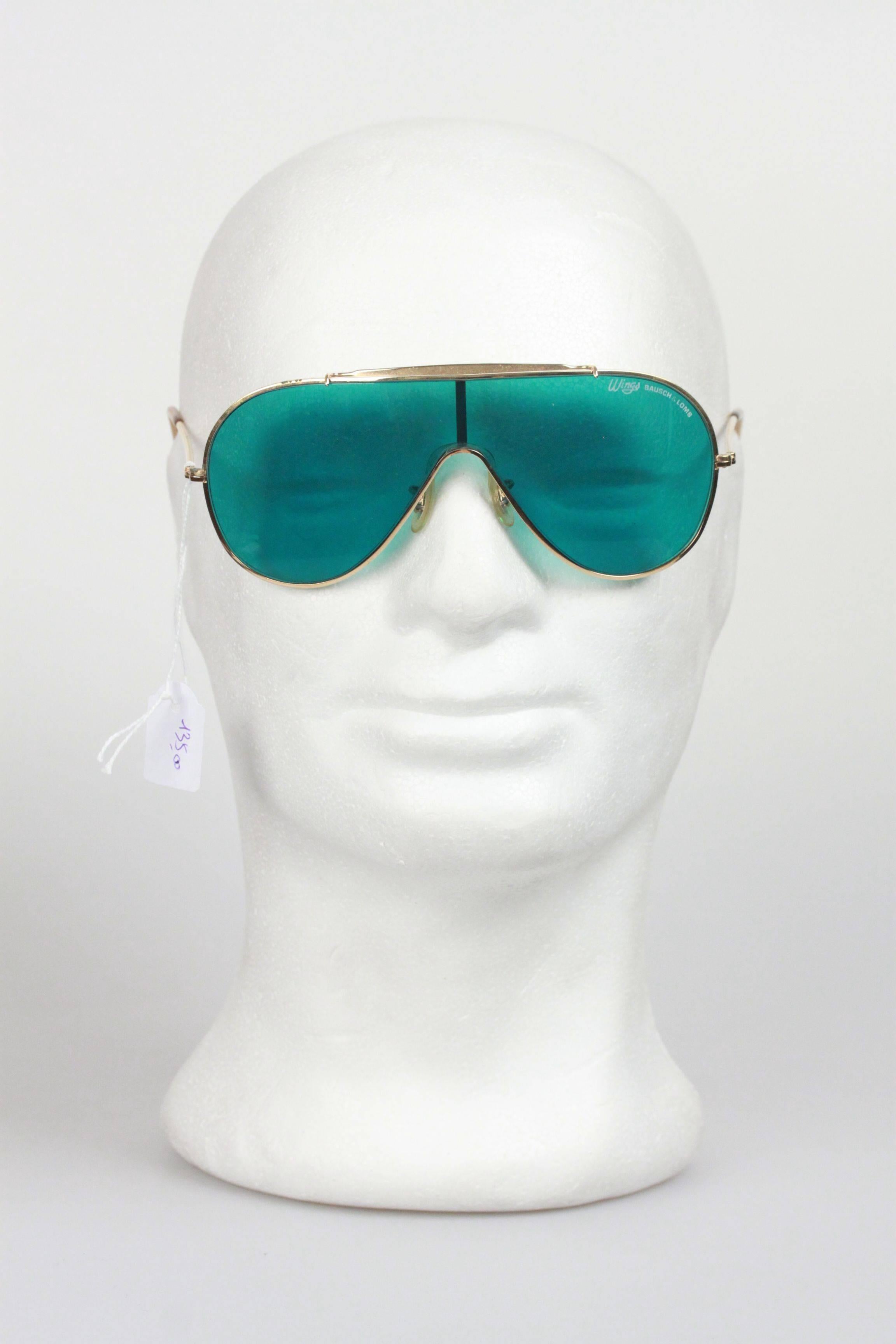 - Vintage Bausch & Lomb Ray-Ban Wings
- Original BAUSCH & LOMB one-piece lens in  green olor
- The gold brow bar improves the fit and feel against the face, 
- The top of the nose bridge is marked B&L Ray-Ban USA
- The lens is laser etched 