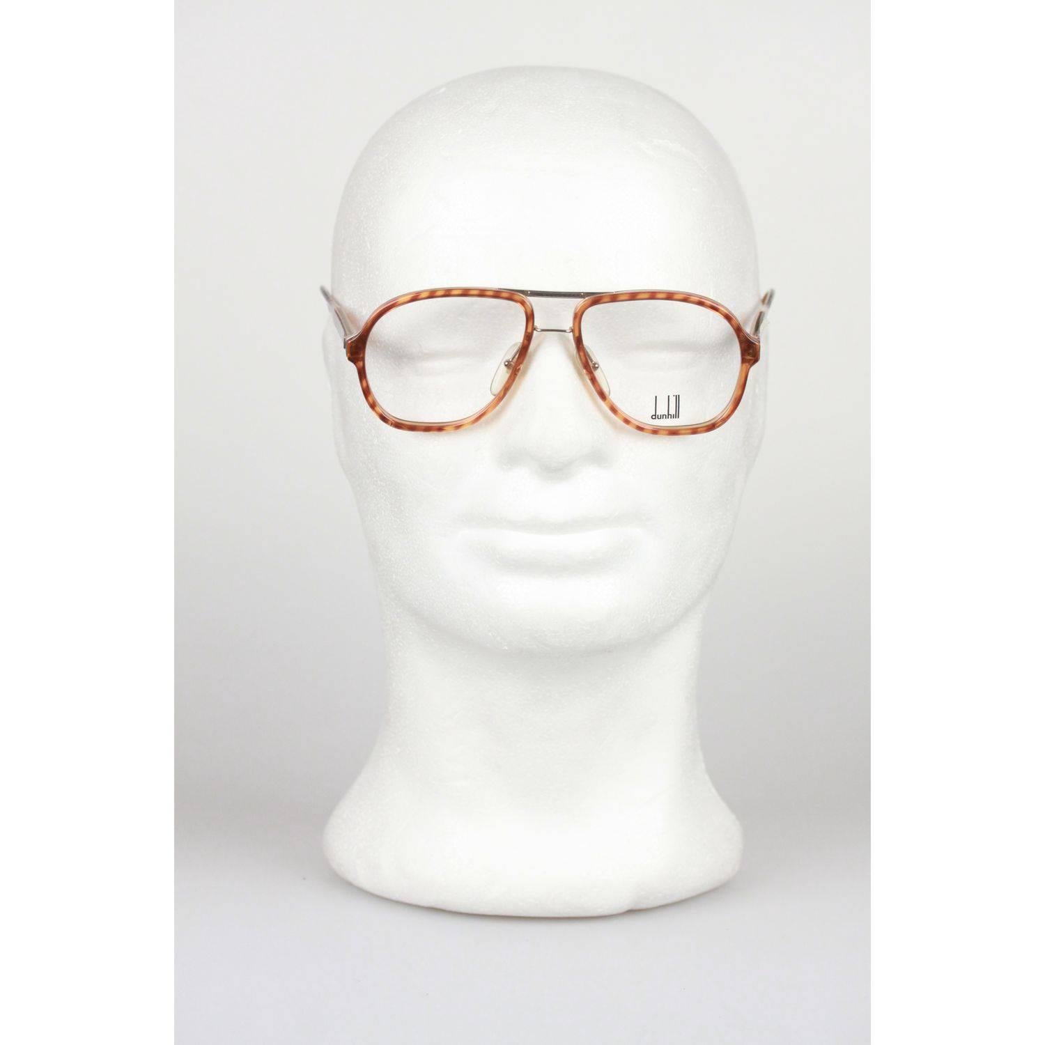- Aviator-shaped Alfred Dunhill eyeglasses
- Premium quality Optyl LCM frame from the eighties
- Brown tortoise plastic frame with metal double bridge
- Clear demo lenses withembossed DUNHILL logo
- Made in Germany

Style & ref.: 6077 - 11 -