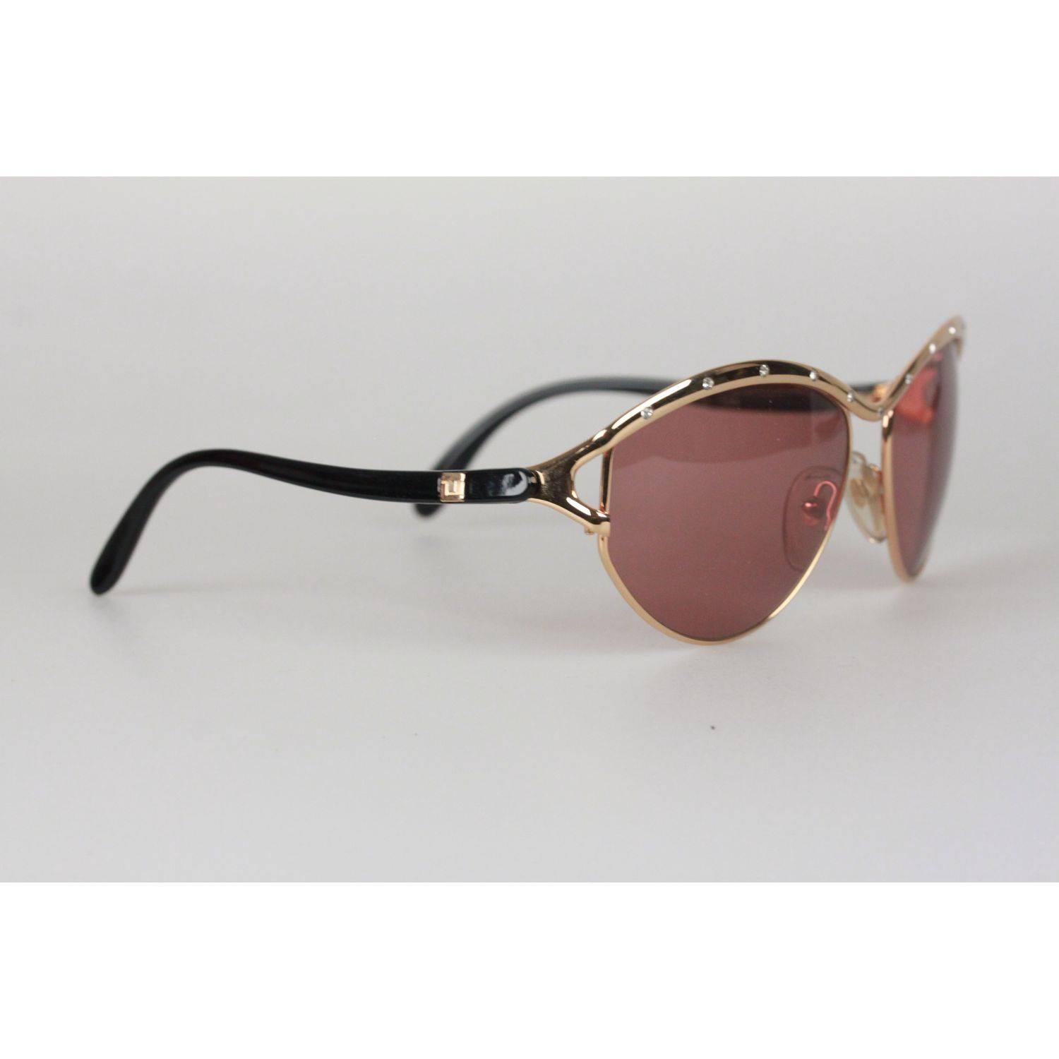 Oversized, gorgeous one-of-a-kind sunglasses by Ted Lapidus, Paris
Gold metal frame with black acetate arms
Rhinestones finish on the top
Brown original lens
Measurements:
- TEMPLE MAX. LENGTH: 110 mm
- TEMPLE TO TEMPLE - MAX WIDTH: 135 mm
- EYE /